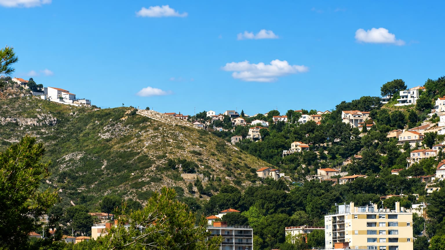 Houses scattered across pine-covered hillsides above apartment blocks in Verduron, northern Marseille.