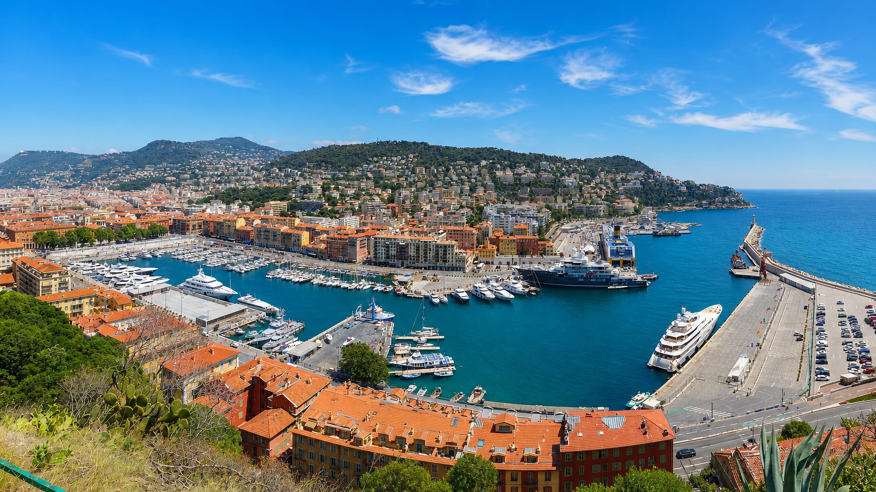 Port Lympia in Nice from above, its yacht basin ringed by ochre and red-roofed quayside buildings.