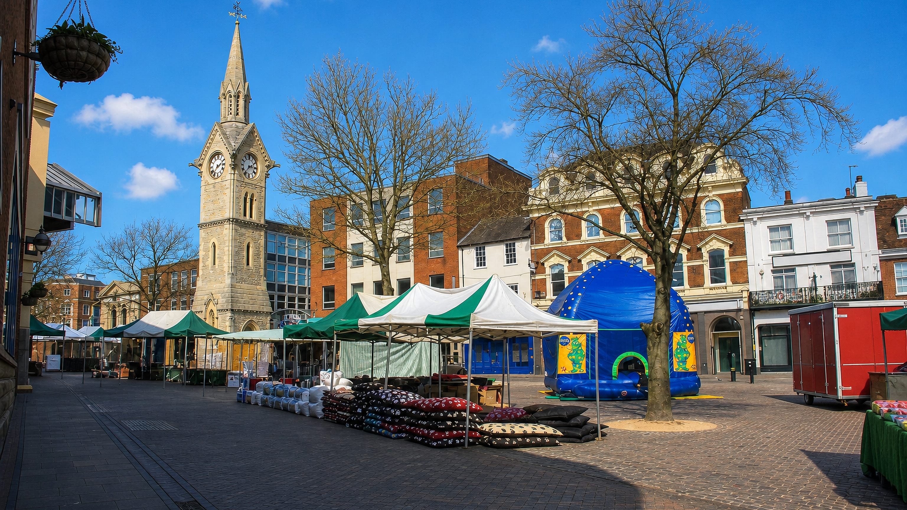 Aylesbury Market Square, England, with the Victorian clock tower rising behind rows of market stalls.