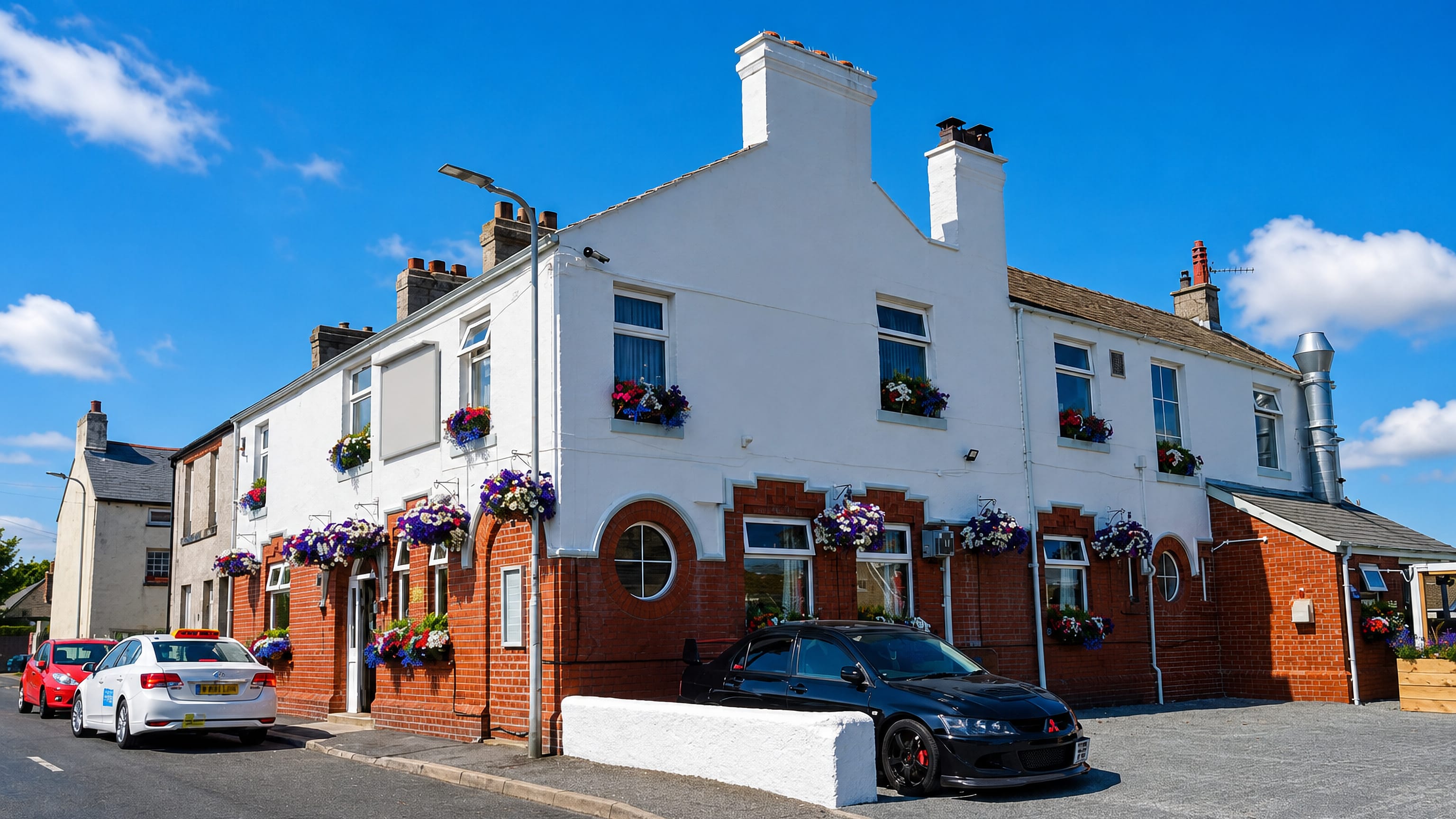 North Scale near Barrow-in-Furness, with a whitewashed corner pub hung with flower baskets on the village street.