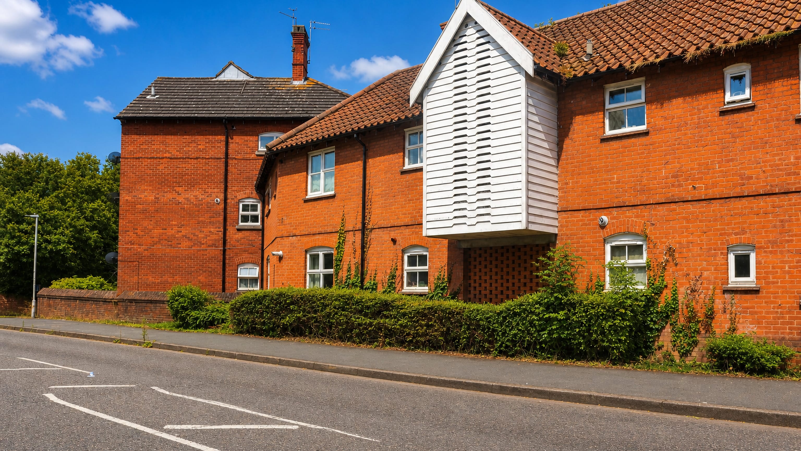 Red-brick houses with a white weatherboarded gable bay on a quiet street in Noak Bridge, Basildon.