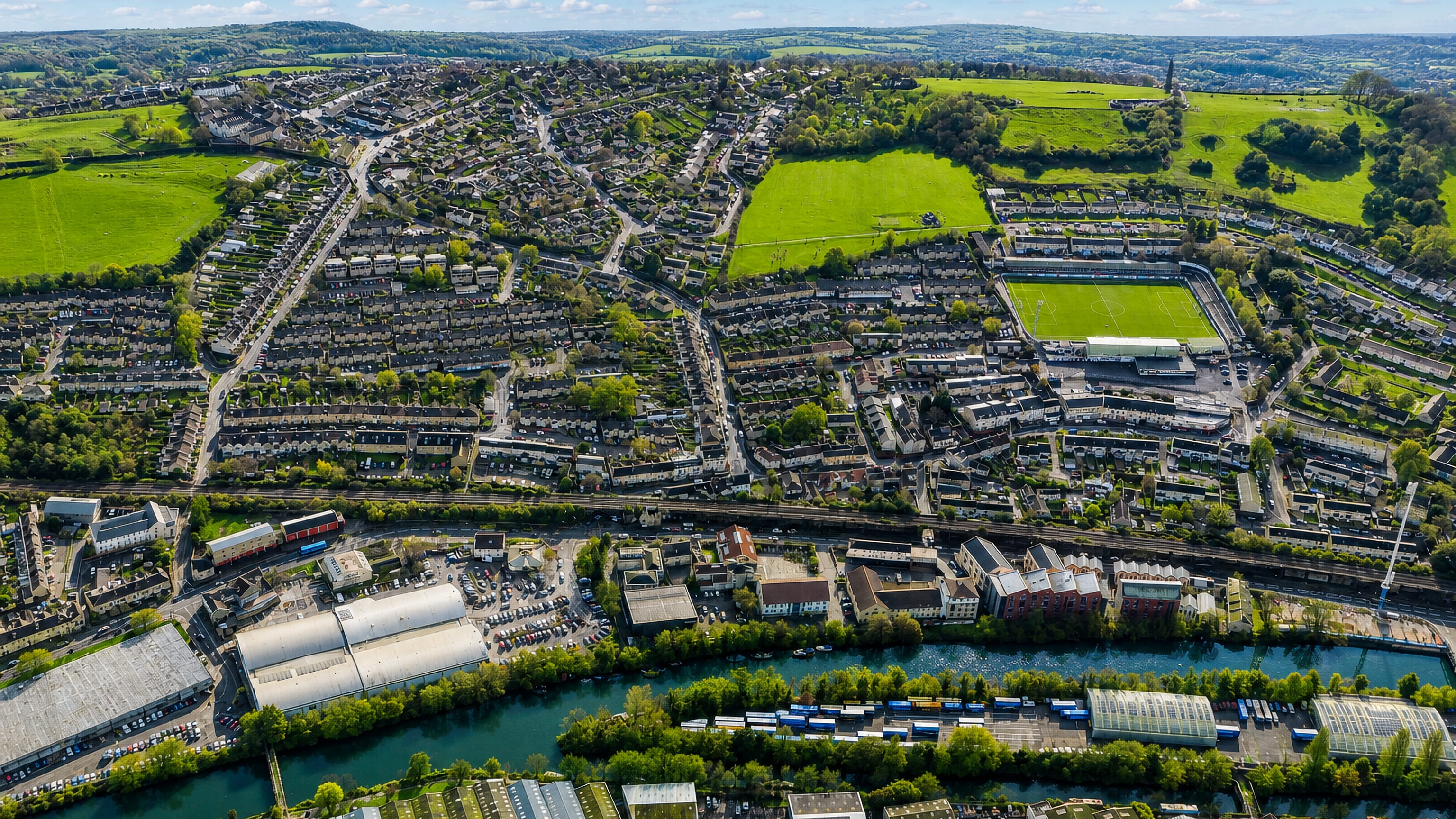 Aerial view of Twerton in Bath, its terraced streets, football ground and riverside works along the Avon valley.