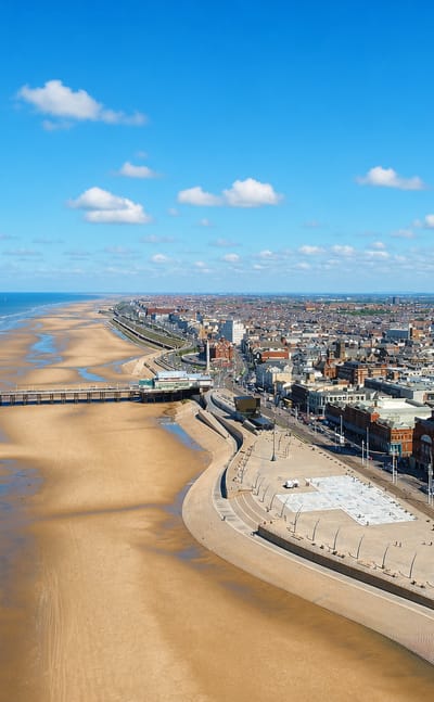 Blackpool Tower rising above the promenade, North Pier and wide sandy beach along the Irish Sea coast
