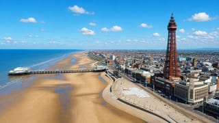 Blackpool Tower rising above the promenade, North Pier and wide sandy beach along the Irish Sea coast