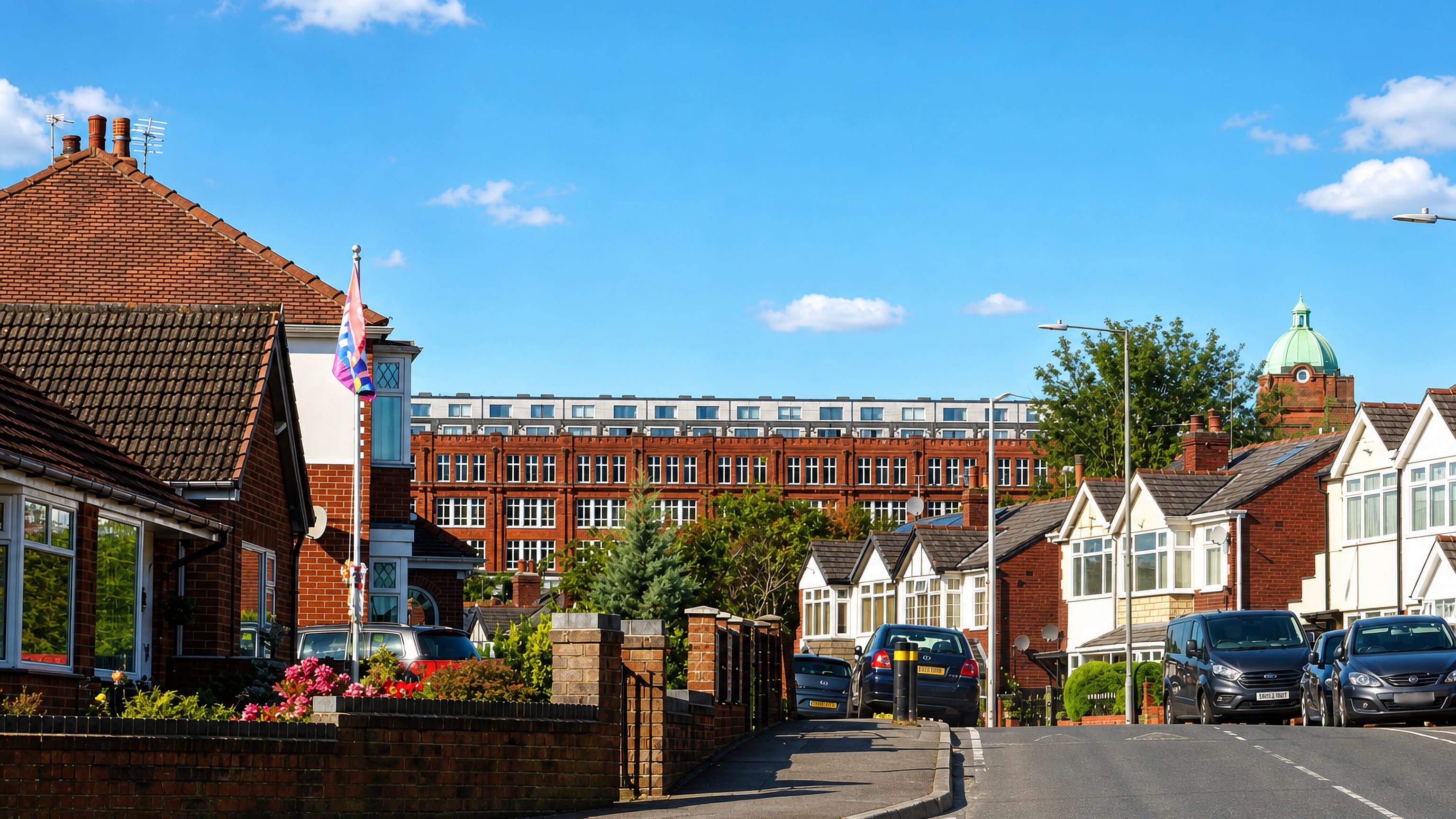 Brick semi-detached houses on an Astley Bridge street in Bolton, with a former mill and domed tower behind.