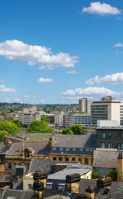 Bradford skyline with City Hall's Italianate clock tower, Victorian stone buildings and distant tower blocks