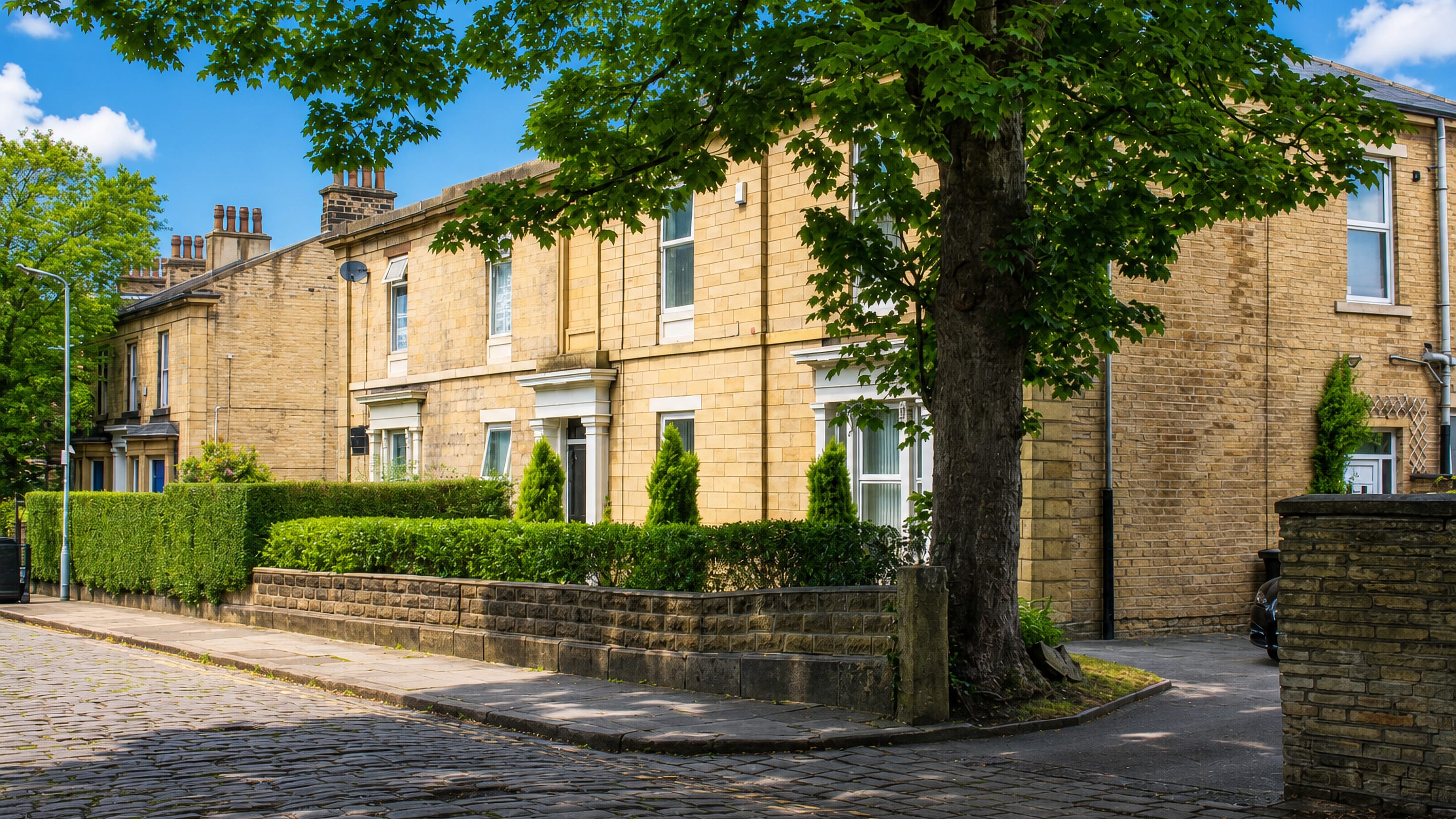Honey-coloured sandstone villas along a cobbled street in Little Horton, Bradford.