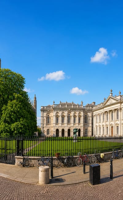 King's College Chapel and the neoclassical Senate House in central Cambridge, England, under a clear blue sky.