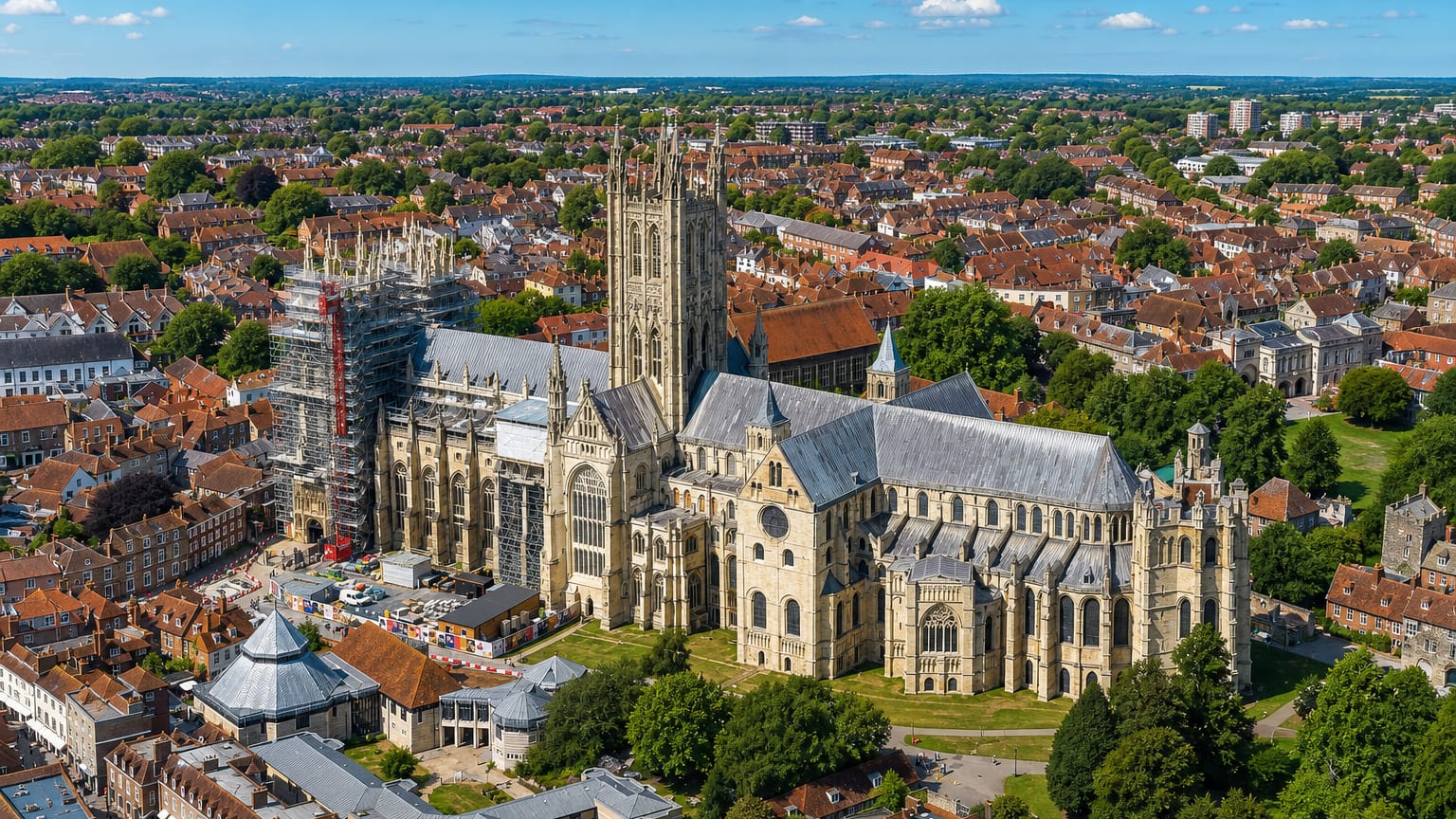 Aerial view of Canterbury Cathedral and its Bell Harry tower amid the medieval town's red-roofed streets