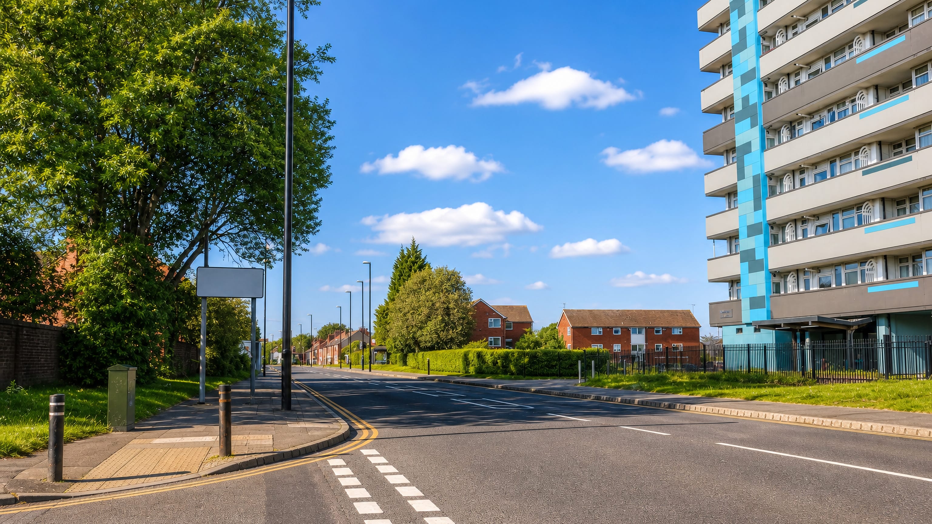 High-rise block and brick housing beside the main road through Bell Green, Coventry.