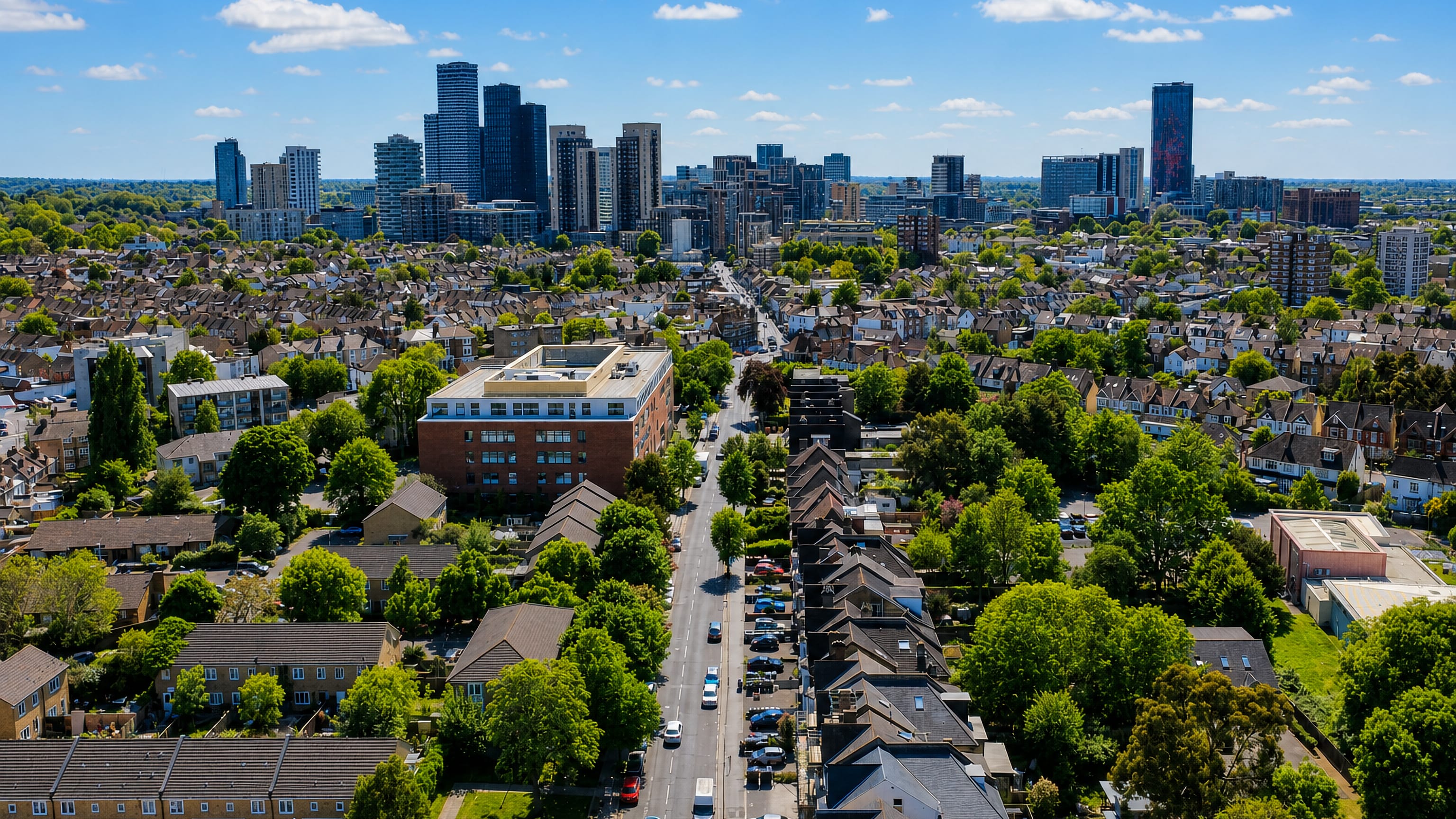 Aerial view over Broad Green's terraced streets in Croydon toward the central Croydon high-rise skyline.