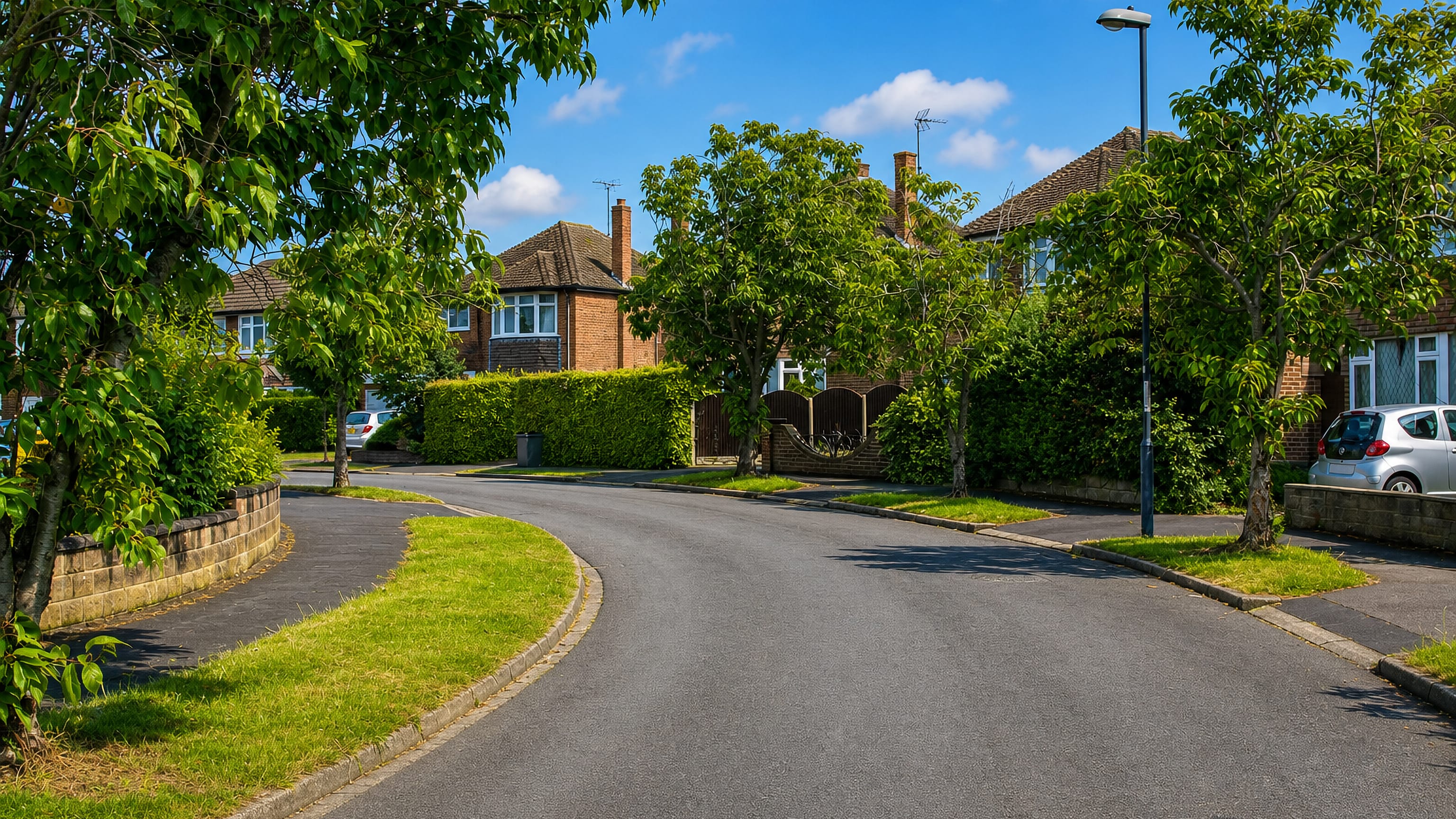 Quiet tree-lined street of brick houses and clipped hedges in Shelton Lock, Derby.