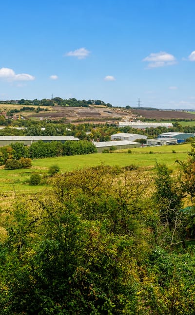 Wooded hillside above industrial units and open fields at Hanging Heaton, Dewsbury
