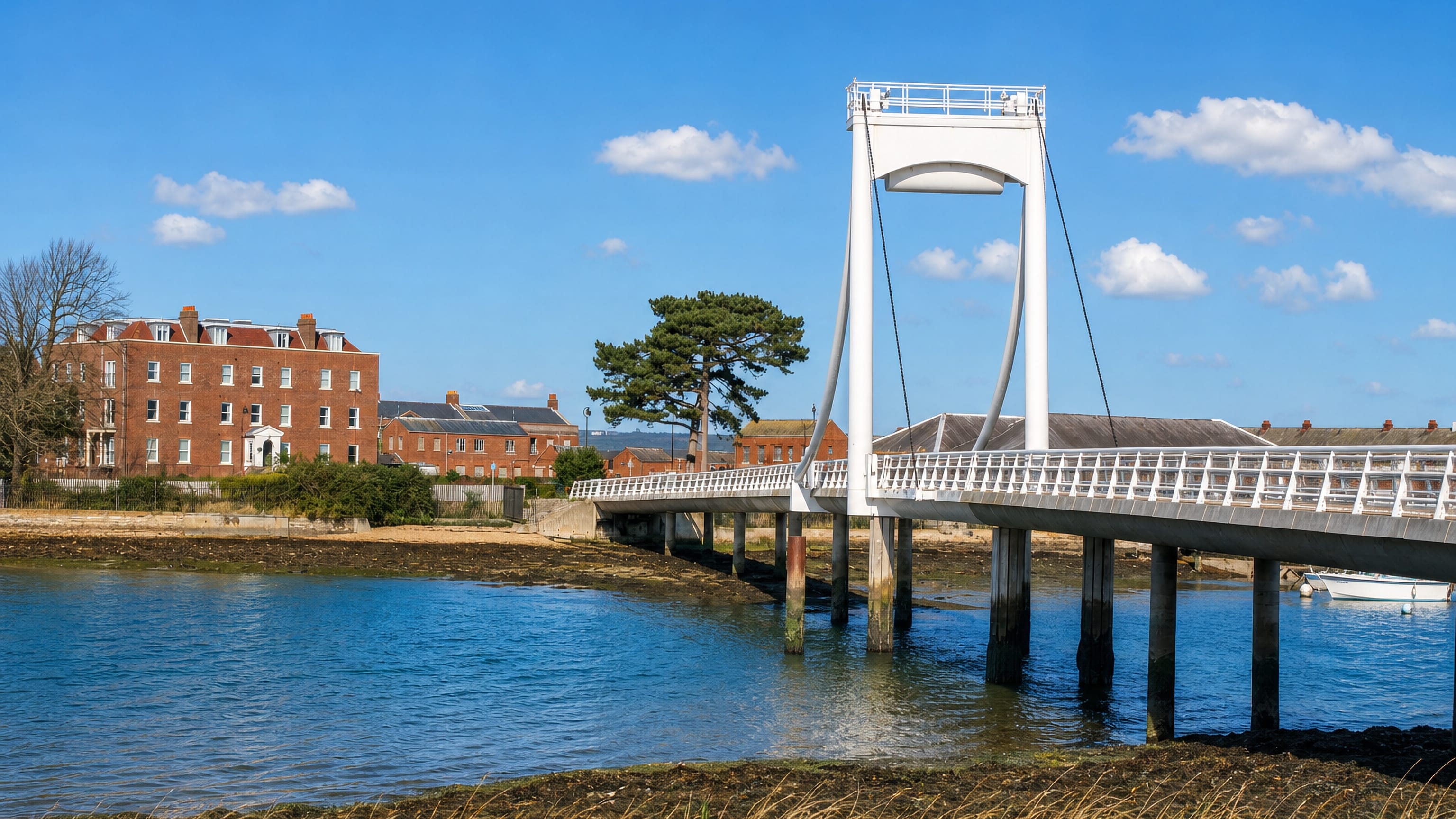 White footbridge crossing the tidal creek at Gosport, England, with Georgian brick houses on the far bank.
