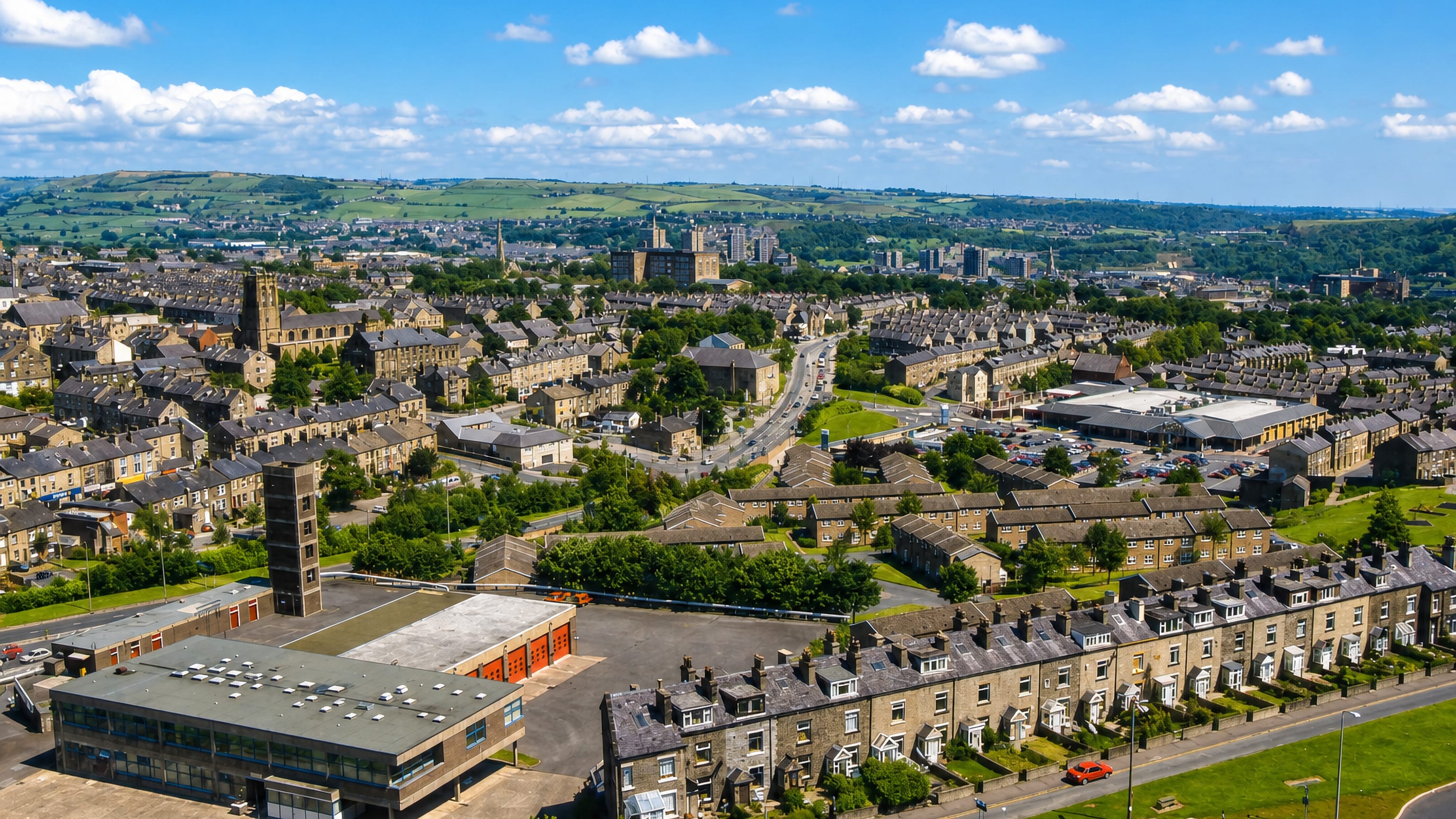 Stone terraced streets and a church tower below the Pennine hills in King Cross, Halifax.