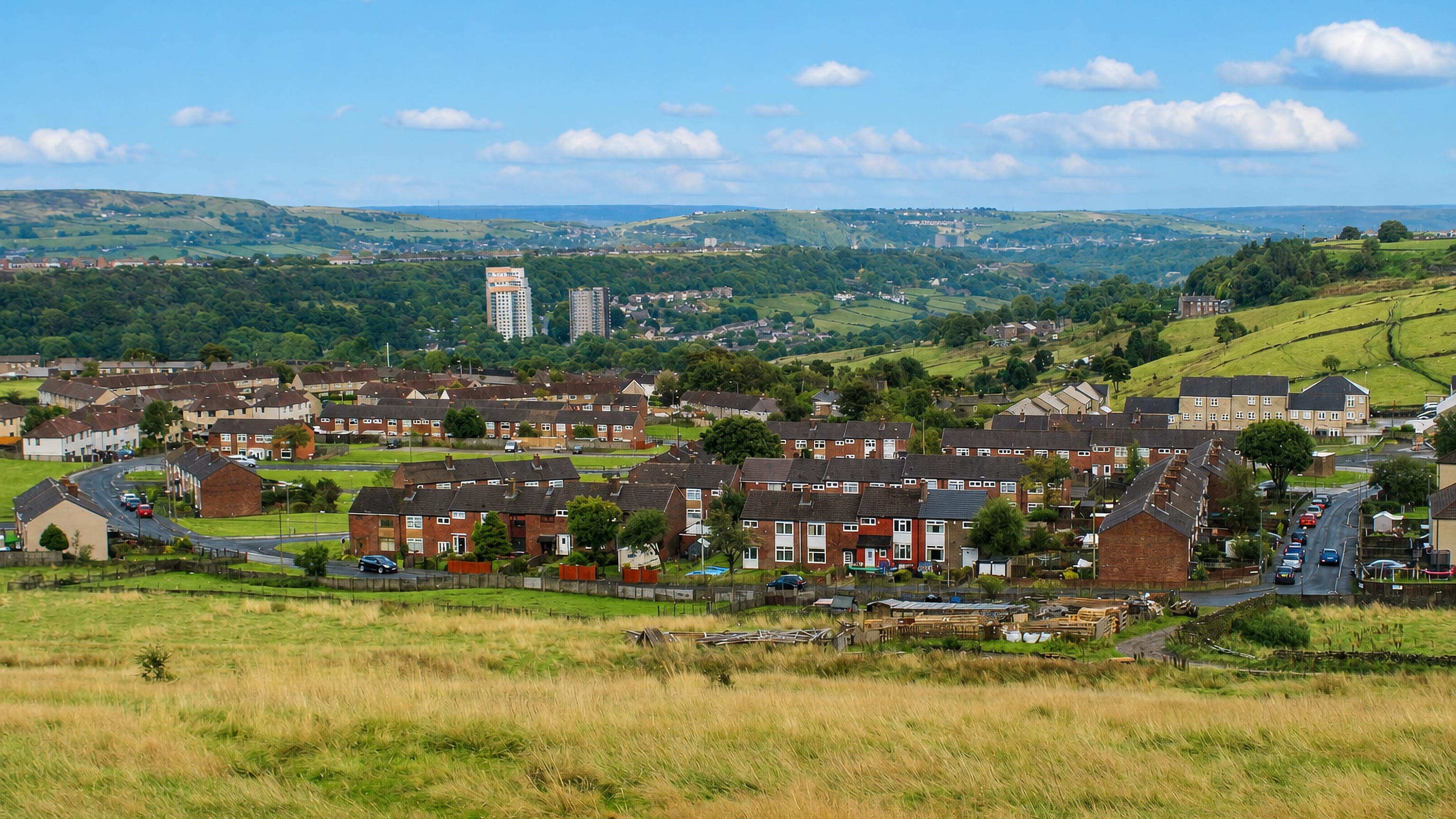 Mixenden's brick terraces and tower blocks on the Pennine hillside above Halifax, moorland fields beyond