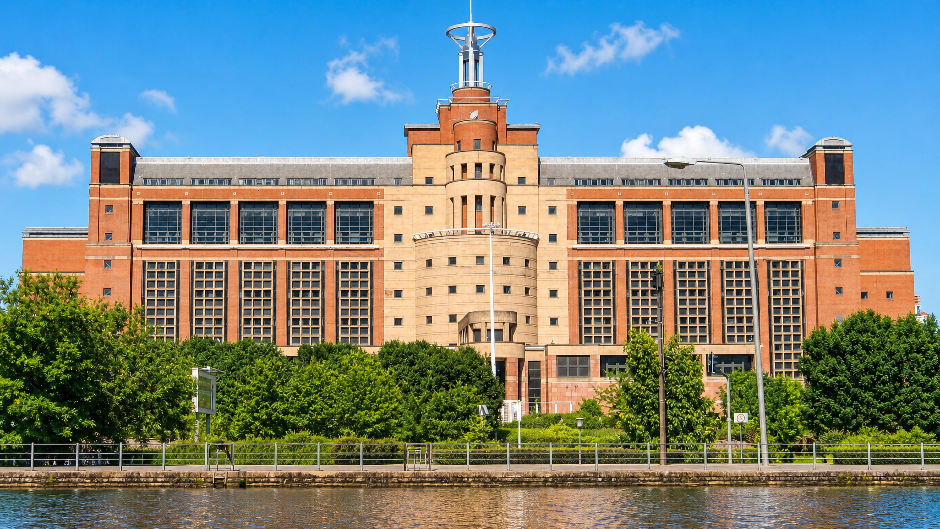 The red-brick Quarry House with its rotunda and mast, the landmark of Quarry Hill in Leeds, seen across water