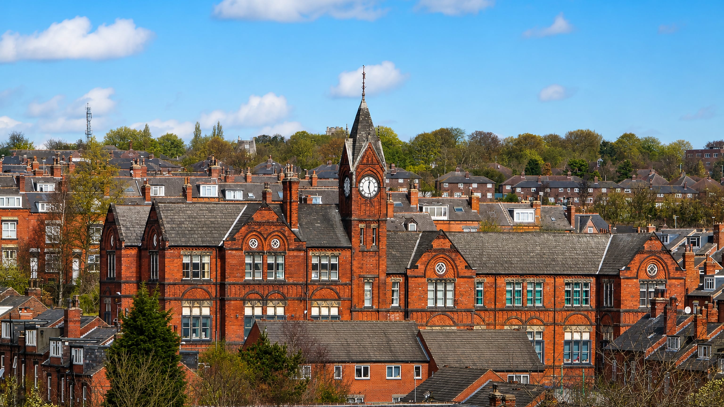 Red-brick Victorian terraces and a clock-tower building above the rooftops of Woodhouse, Leeds.
