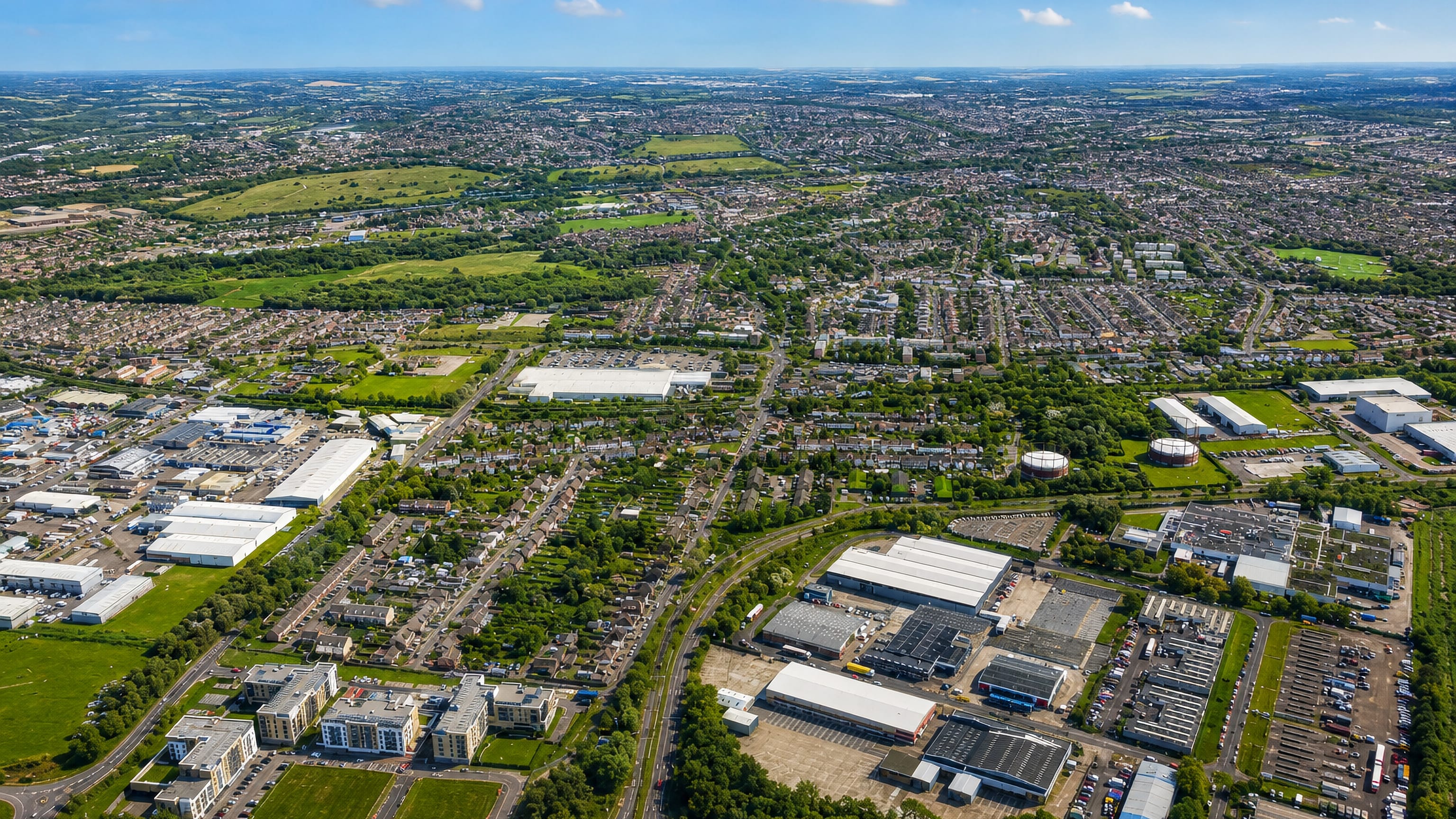 Aerial view over Belvedere in southeast London, with suburban terraces, green spaces and riverside industrial estates.