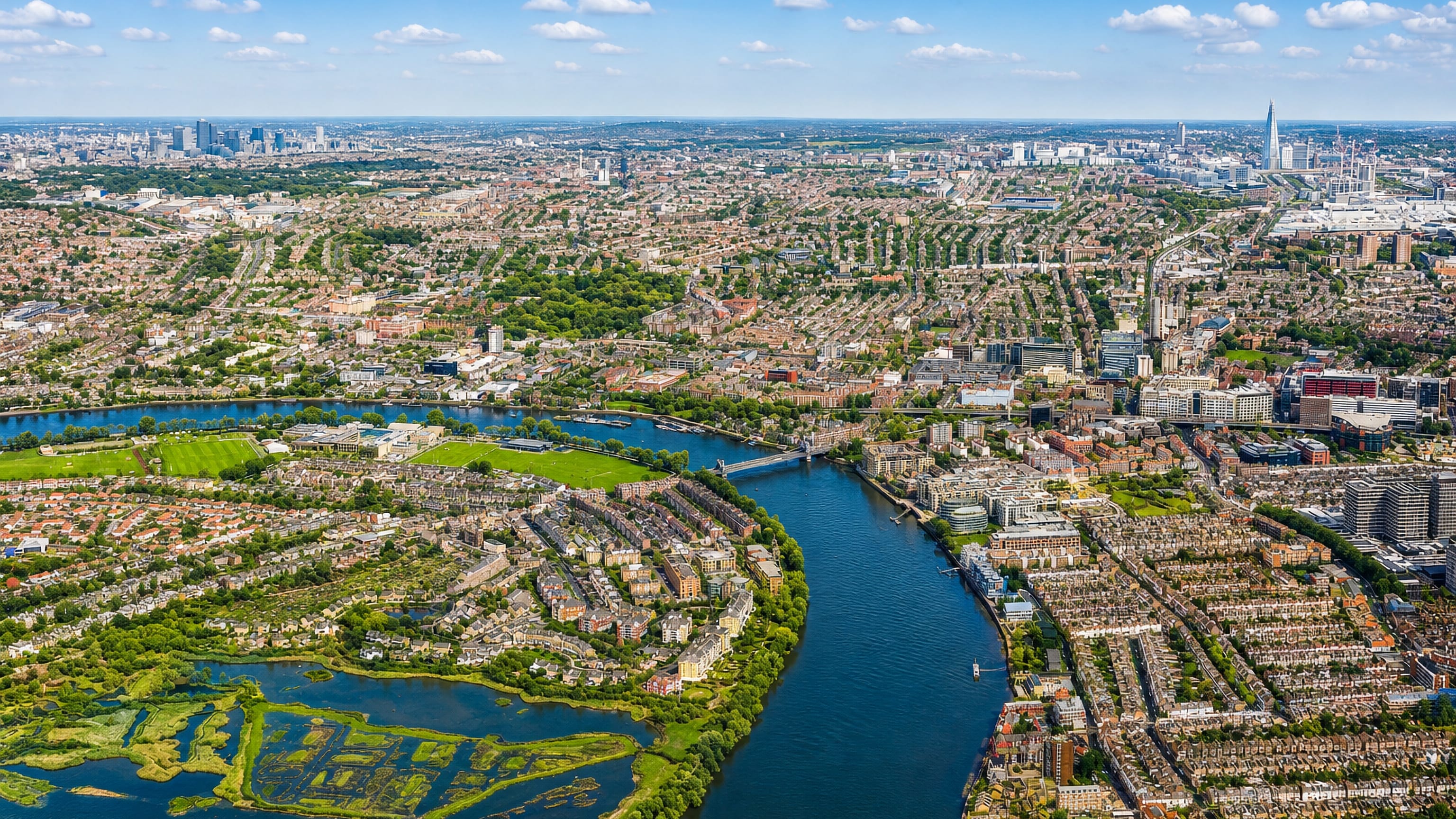 Aerial panorama of west London's Thames bend and terraced rooftops, the wider setting of the Earls Court district.