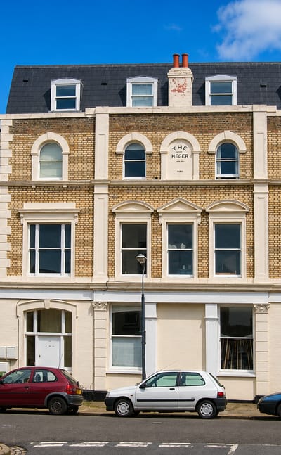 Victorian brick terrace houses with parked cars on a residential street in East Dulwich, London