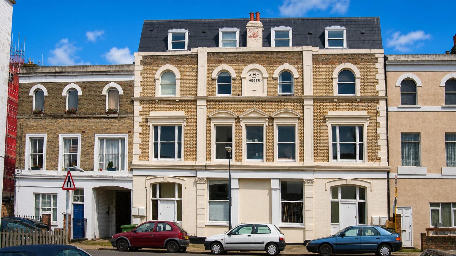 Victorian brick terrace houses with parked cars on a residential street in East Dulwich, London