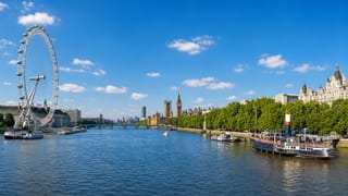 London's River Thames with the London Eye, Big Ben and the Houses of Parliament under a bright blue sky