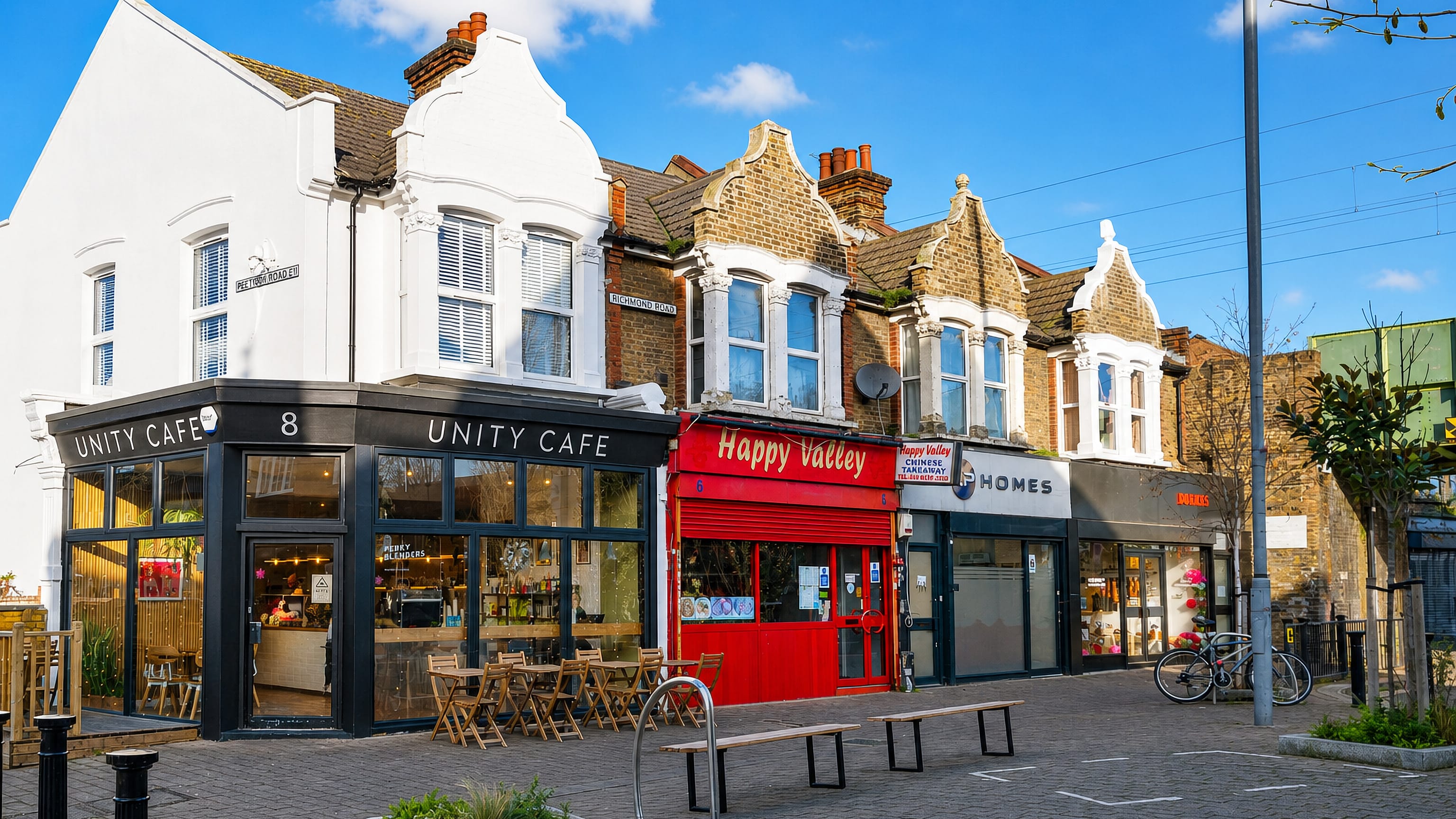 Victorian parade of shops with a cafe and Chinese takeaway on a sunny Leytonstone high street, London.