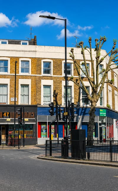 A quiet Maida Hill street corner in London with a pub and parade of shops beside the Elgin Avenue W9 sign