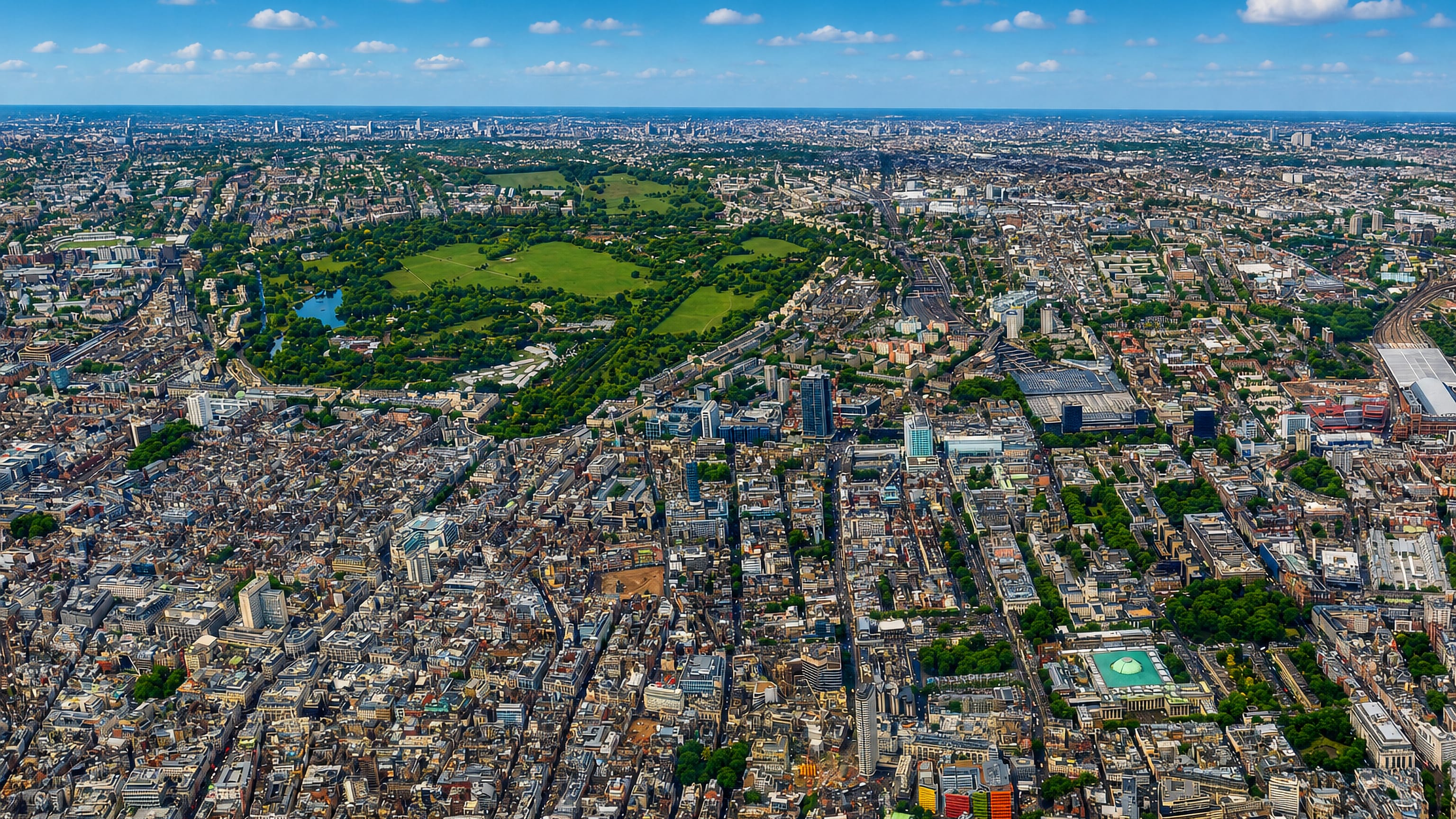 Aerial view over dense central London rooftops with a large green park near Marylebone