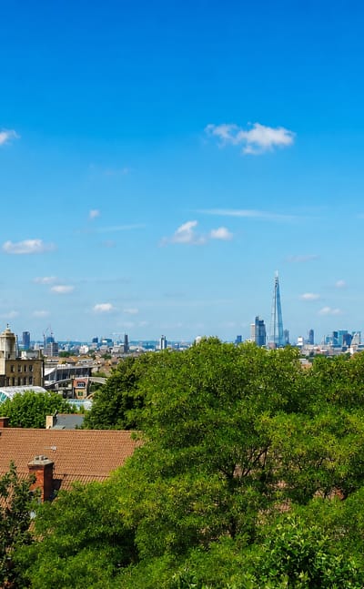 View across Peckham rooftops to the distant central London skyline with the Shard on a clear day.