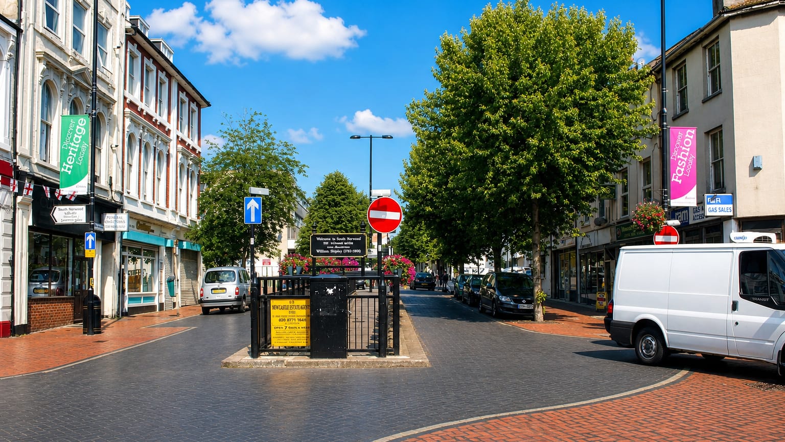 South Norwood high street with its clock-tower monument, shops and a brick-paved road.