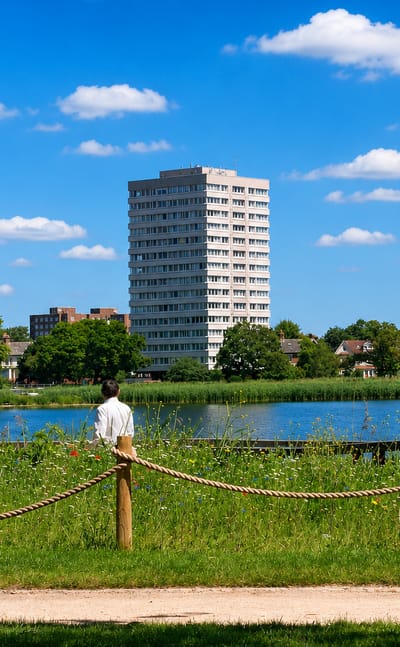 Three residential tower blocks overlooking a reservoir and wildflower meadow near Stamford Hill, London.