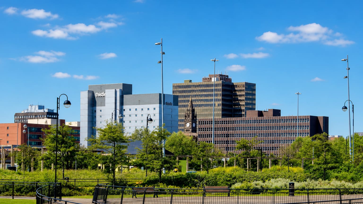 Middlesbrough town-centre skyline of office blocks and a clock tower seen across a landscaped park.
