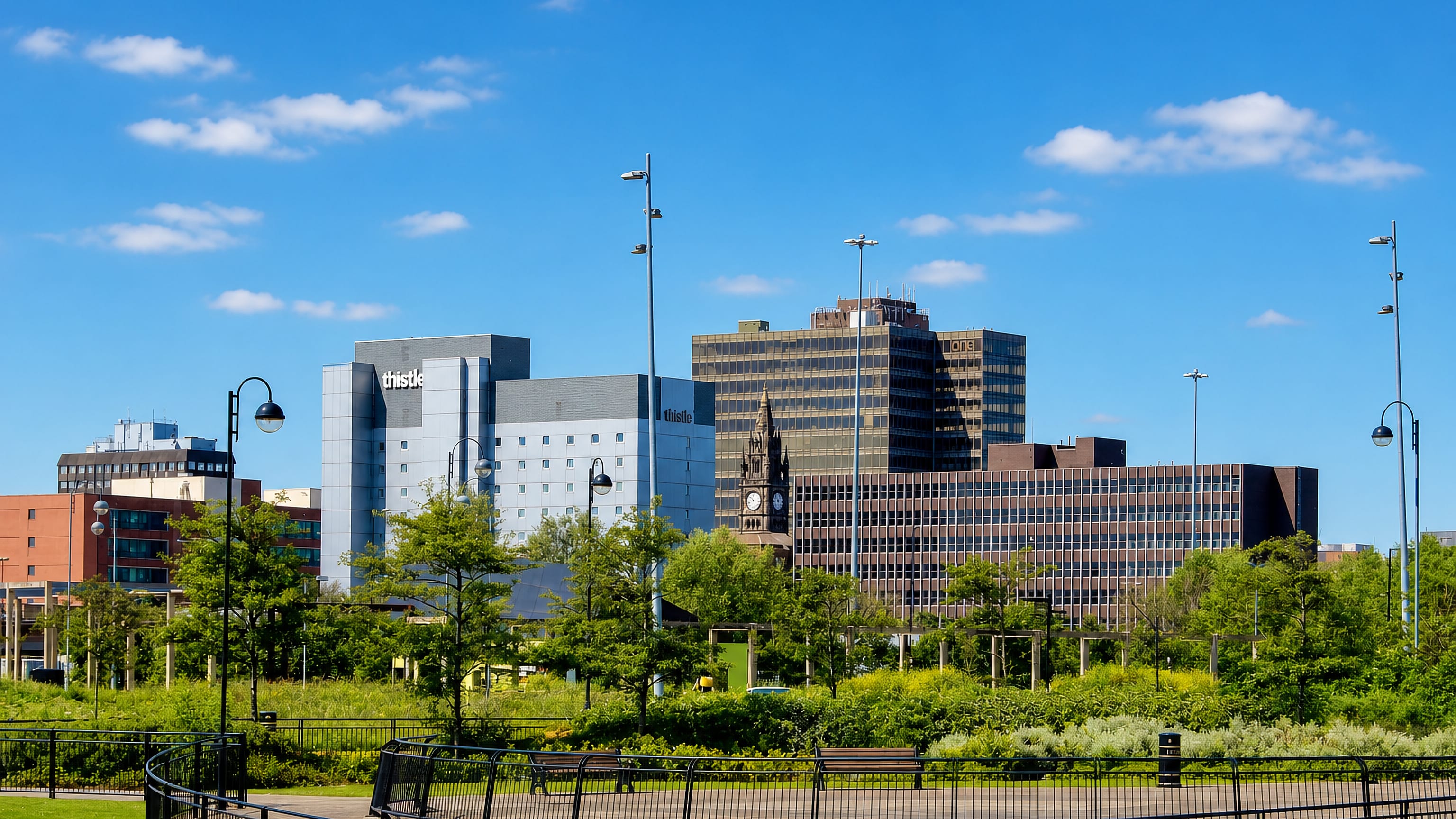Middlesbrough town-centre skyline of office blocks and a clock tower seen across a landscaped park.