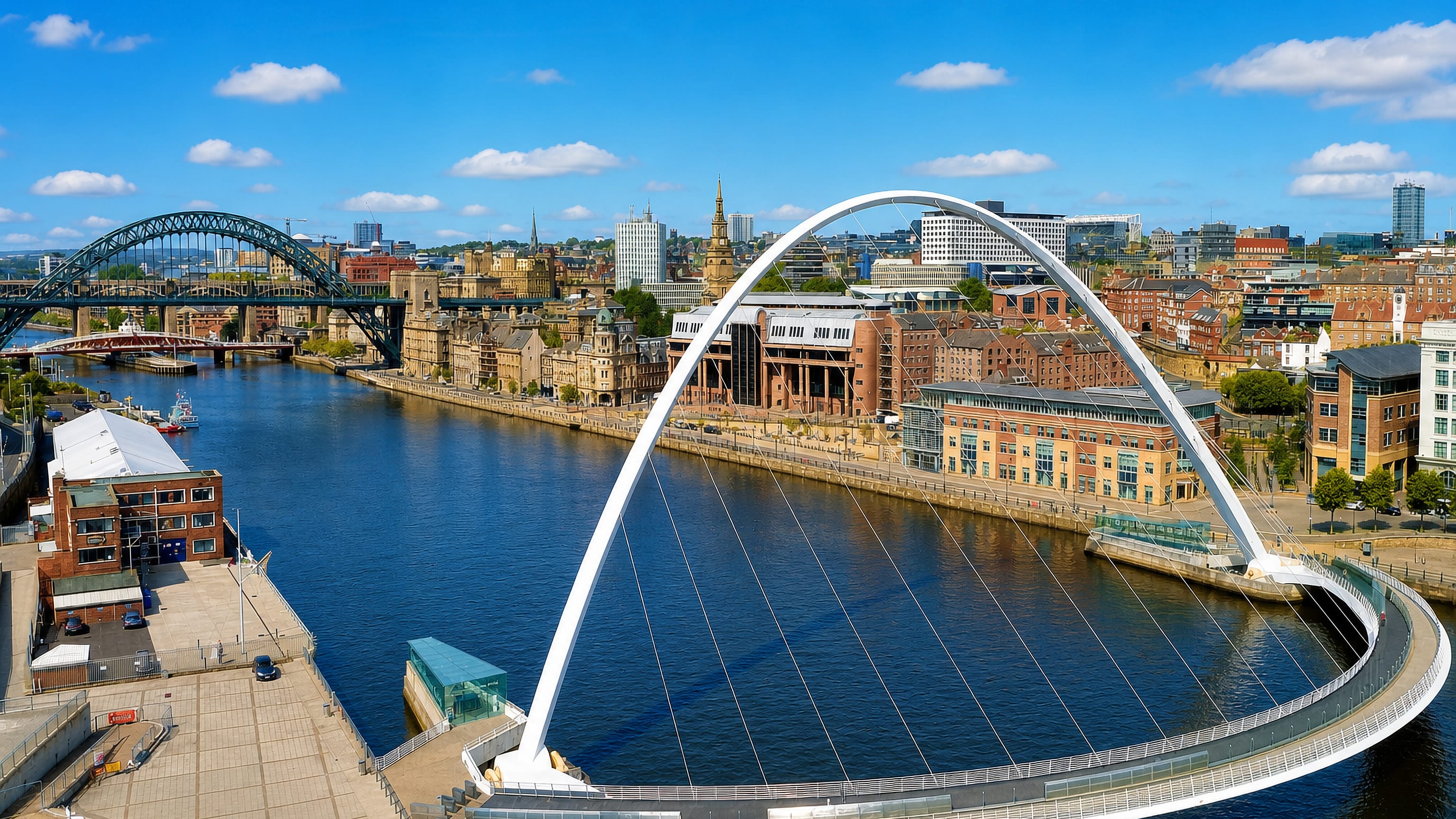 The Gateshead Millennium and Tyne bridges arching over the River Tyne along Newcastle upon Tyne's quayside.