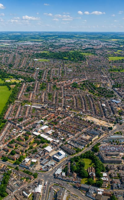 Aerial view of Northampton's terraced streets and a green park stretching to the horizon.