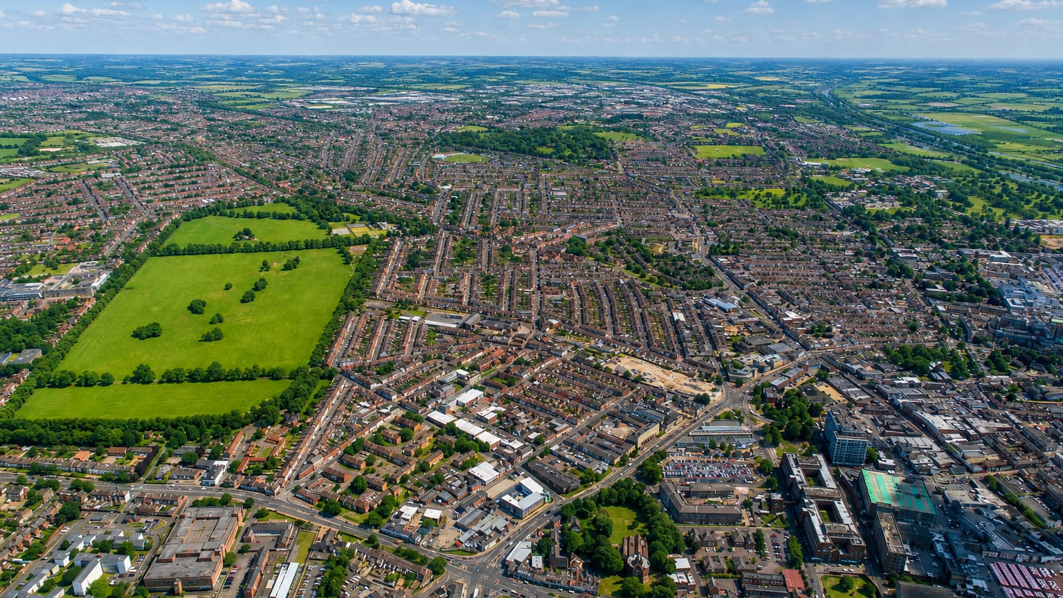 Aerial view of Northampton's terraced streets and a green park stretching to the horizon.