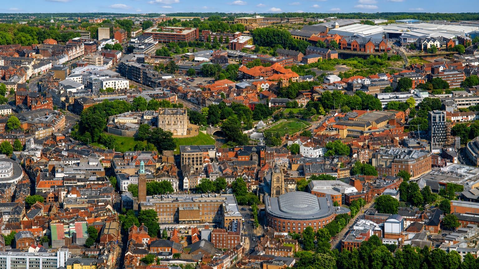 Aerial view of Norwich with its Norman castle keep among the historic city rooftops.