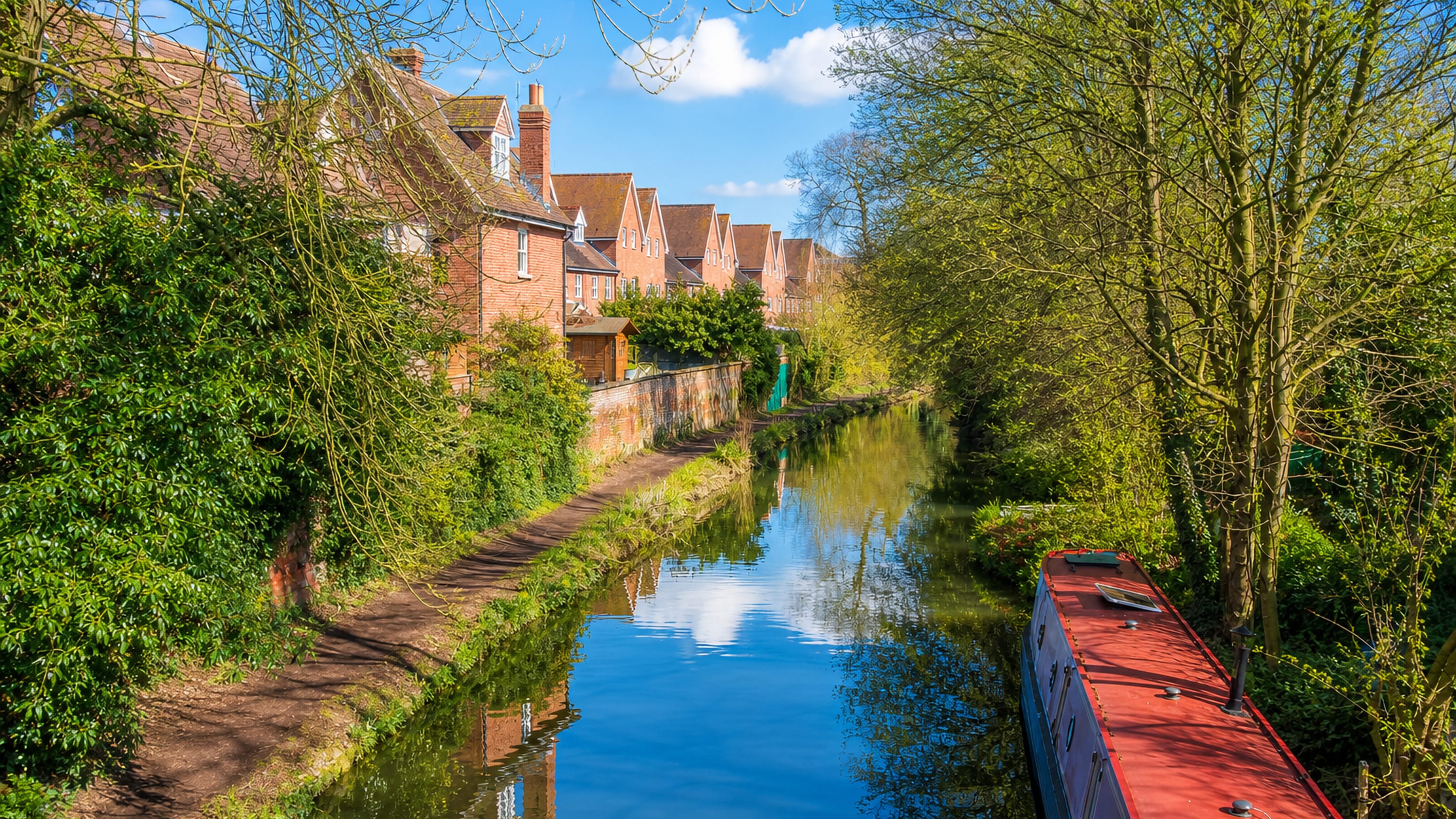 Narrowboat moored on the Oxford Canal beside brick houses in Walton Manor, Oxford.