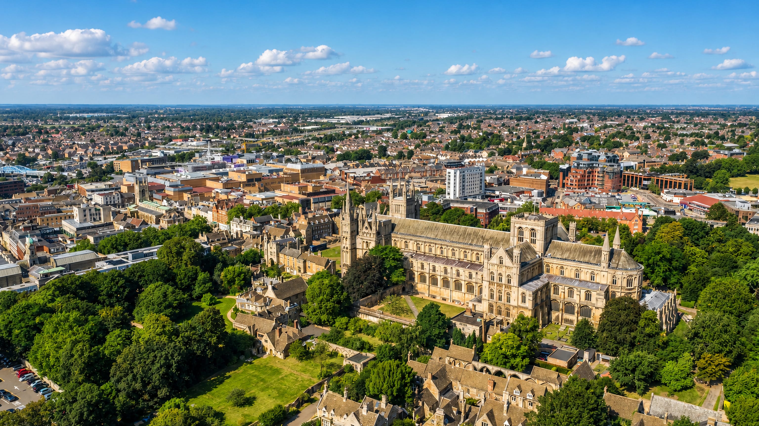 Peterborough Cathedral and its precinct from the air, with the city centre and flat Fenland horizon beyond