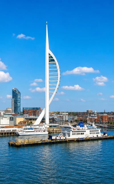 The Spinnaker Tower rises above Portsmouth Harbour with ferries and waterfront buildings.