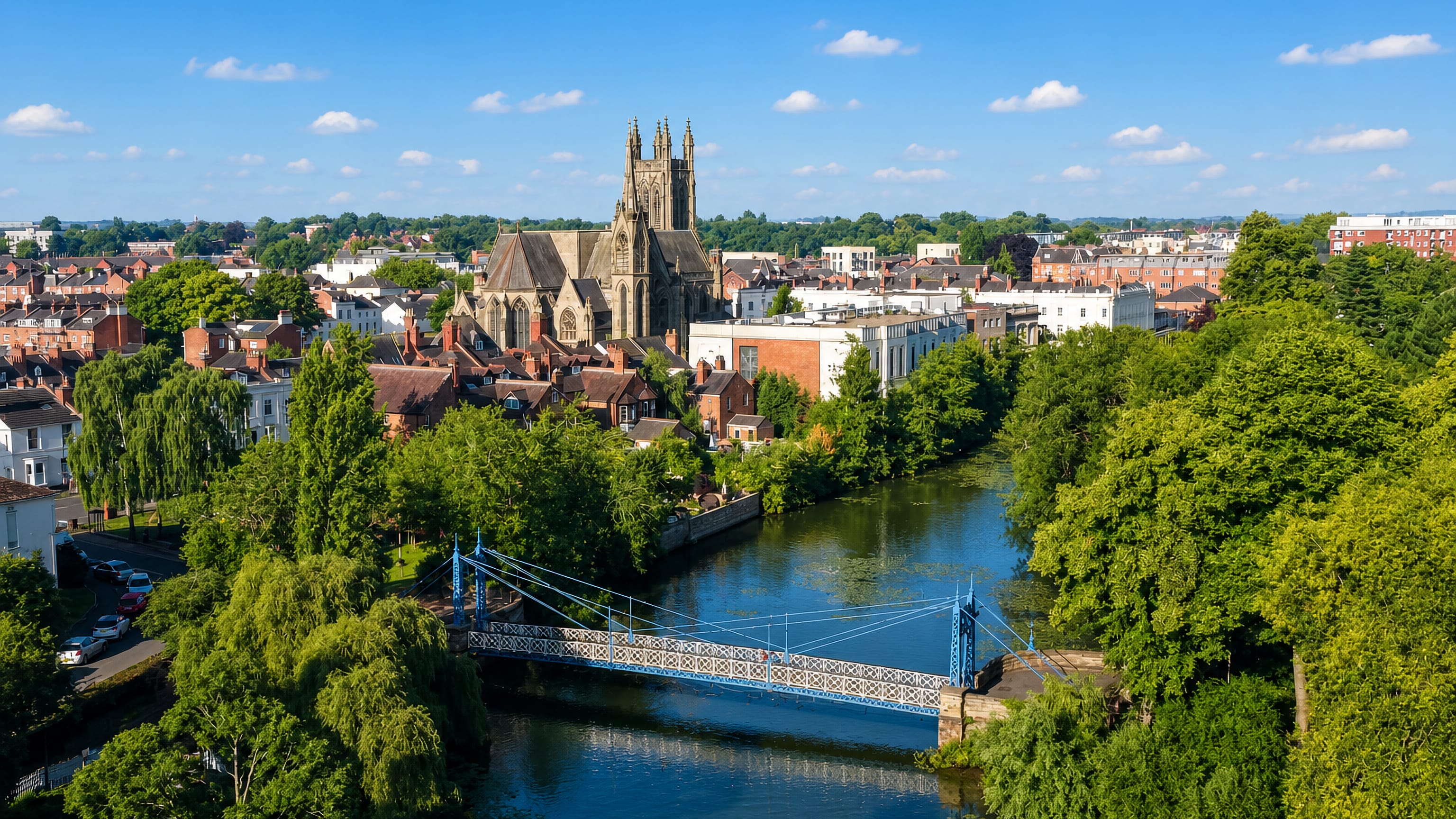 All Saints' Church tower and the blue suspension footbridge over the River Leam in Royal Leamington Spa.