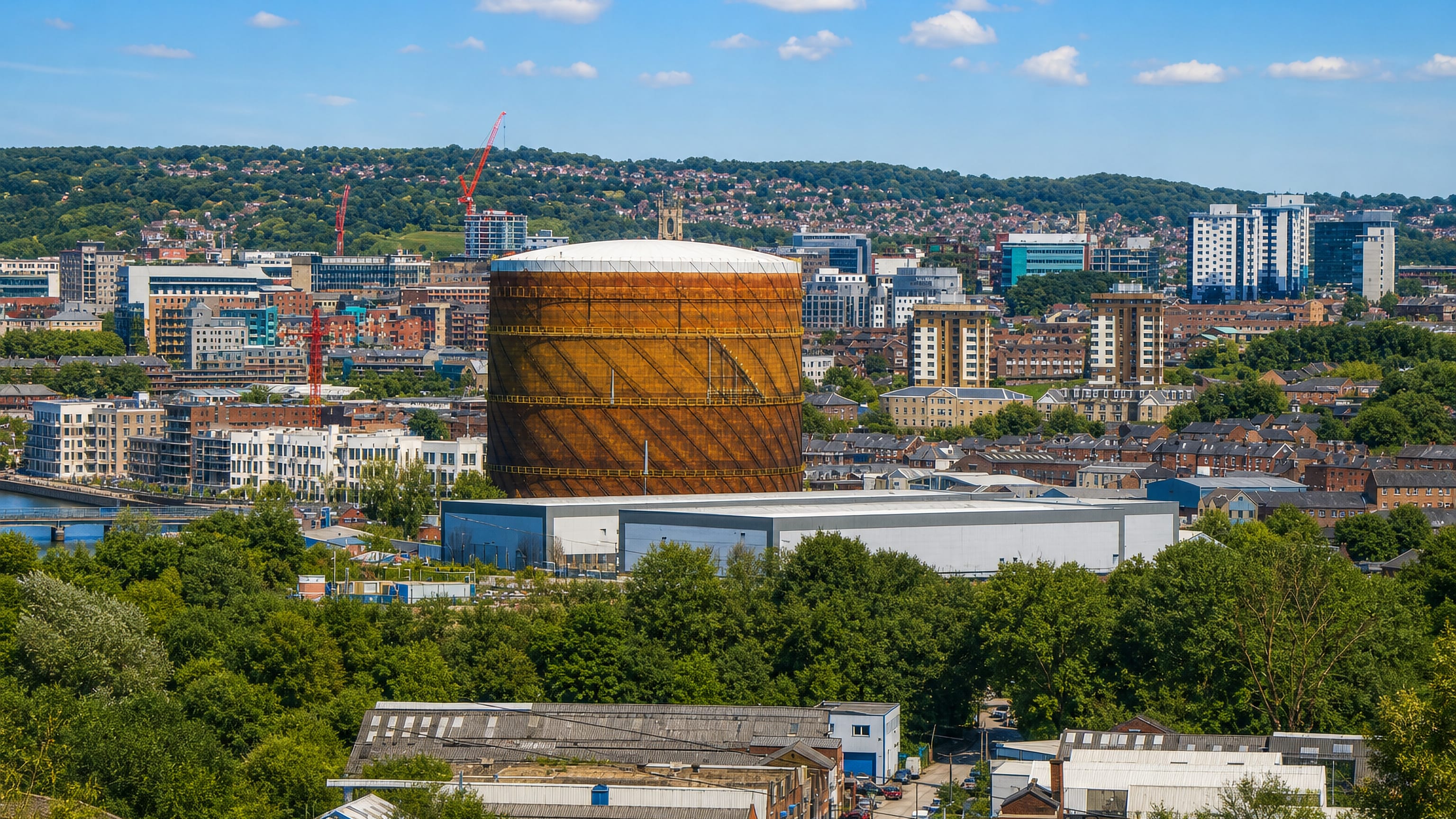 The Neepsend gasholder rising above industrial sheds and Sheffield's hillside skyline.