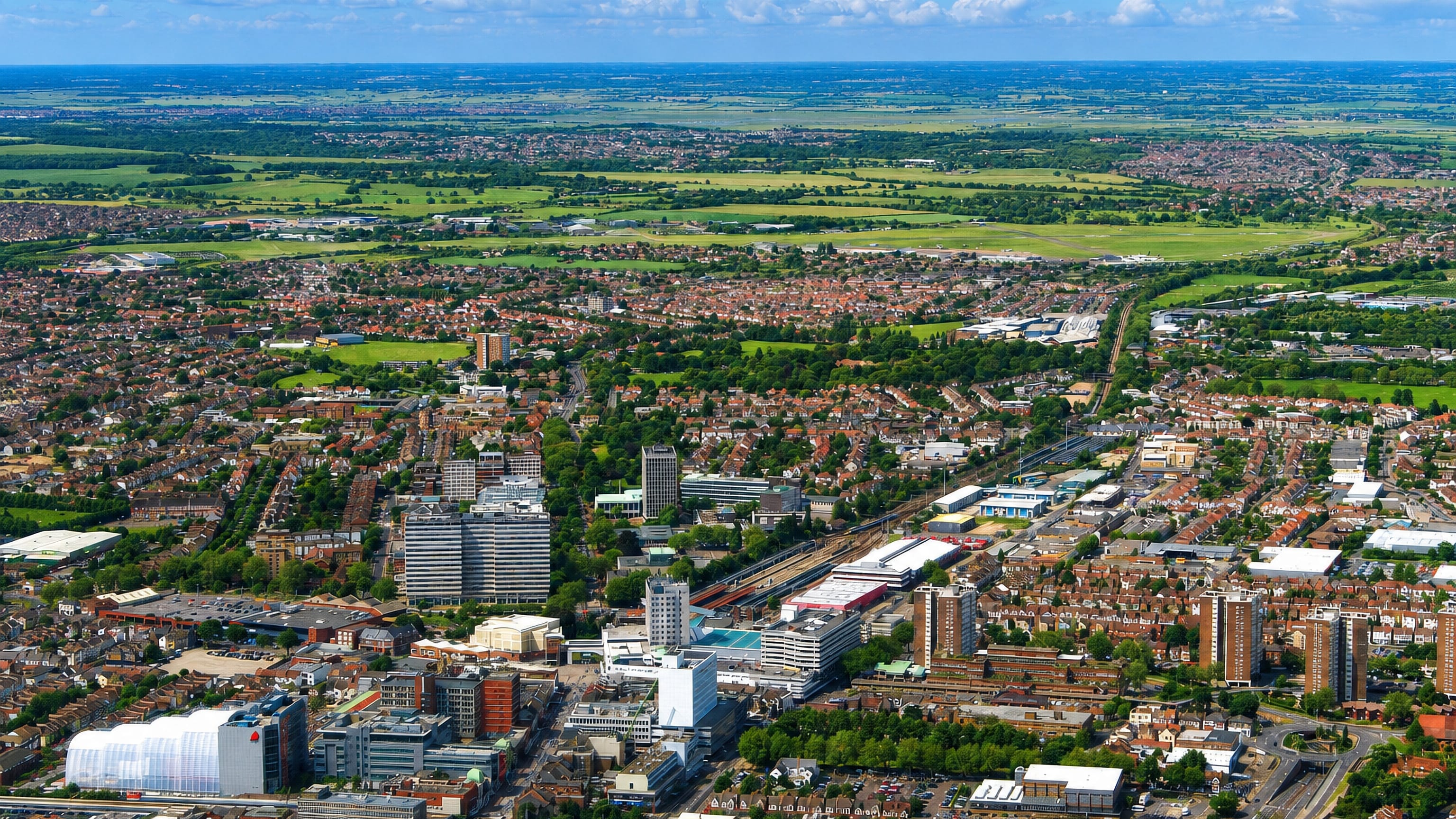 Aerial view over Southend-on-Sea's town centre, office towers and terraced streets reaching open countryside.