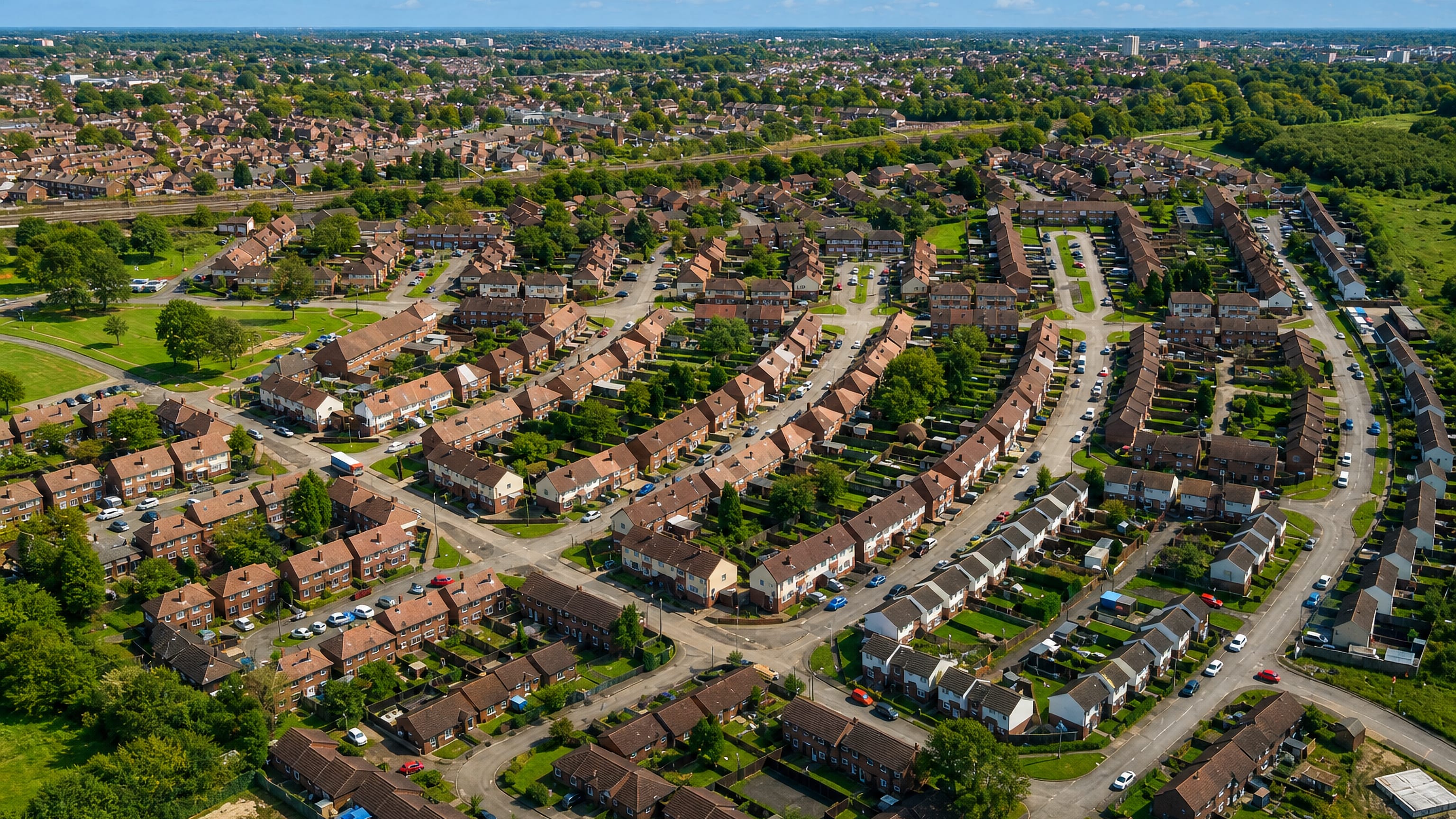 Aerial view of curving streets and brick semi-detached houses across the Adswood estate in Stockport.
