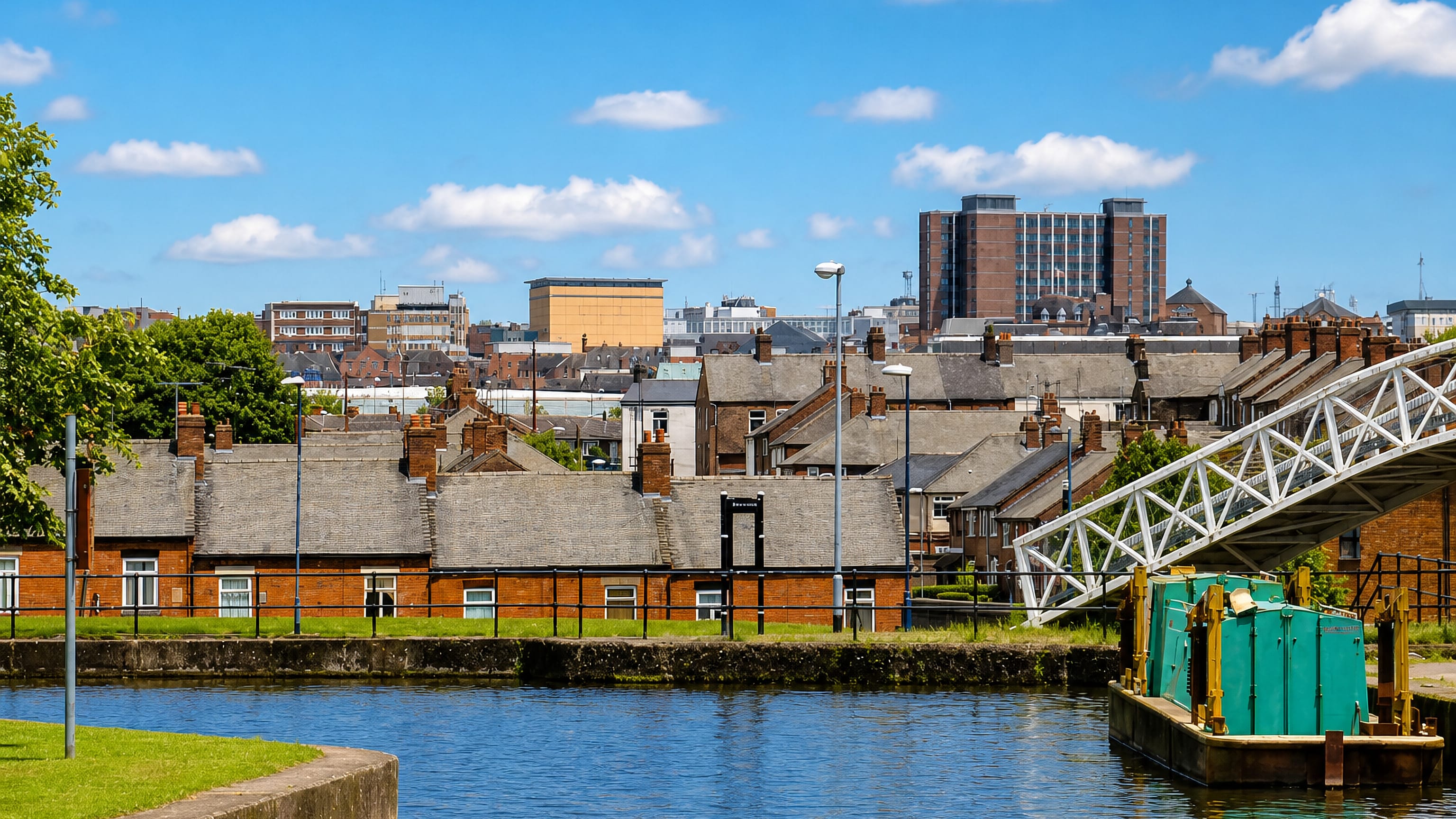 Canal barge beside terraced houses and 1960s tower blocks in Hanley, Stoke-on-Trent.