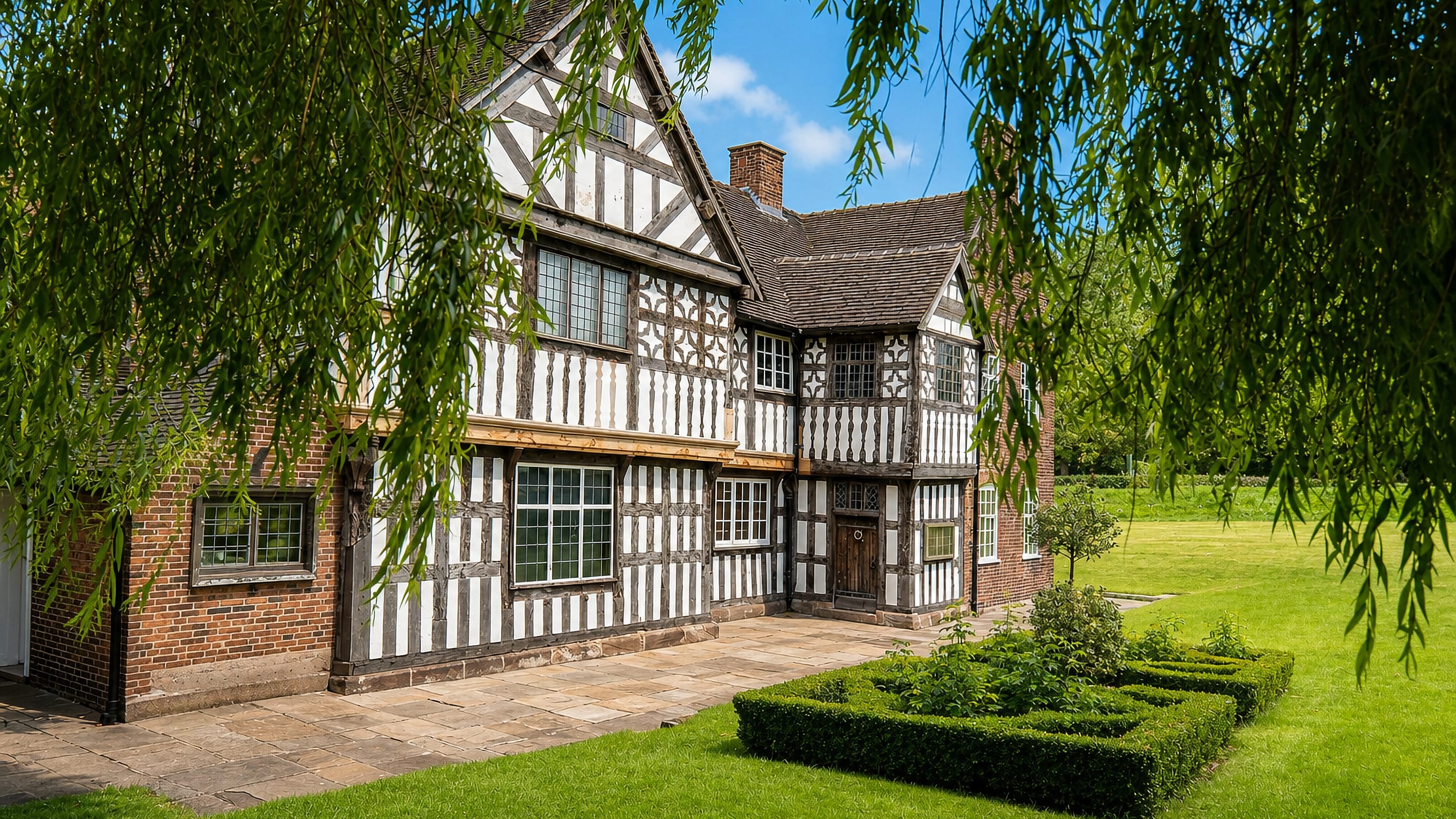 Black-and-white Tudor timber-framed hall with lawns and clipped hedges at Smallthorne, Stoke-on-Trent.