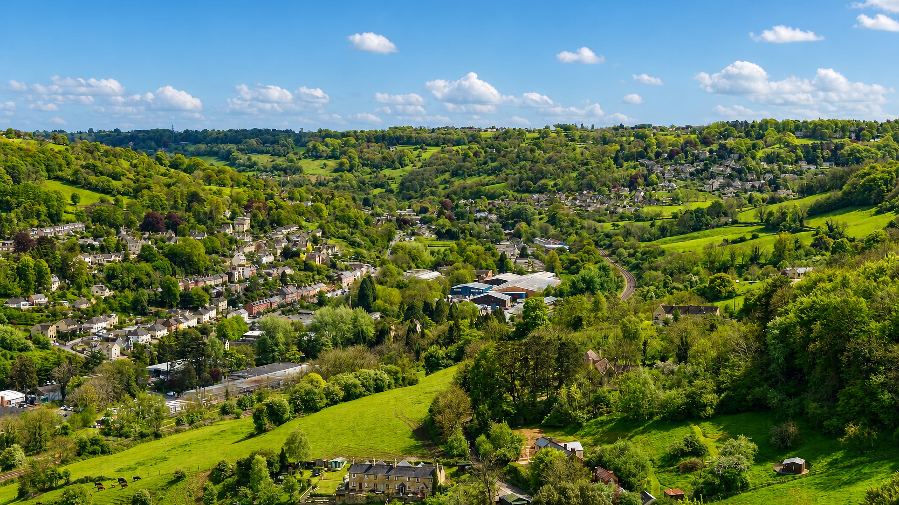 Stone terraces and hillside cottages above wooded pastures in the Stroud valley at Rodborough.