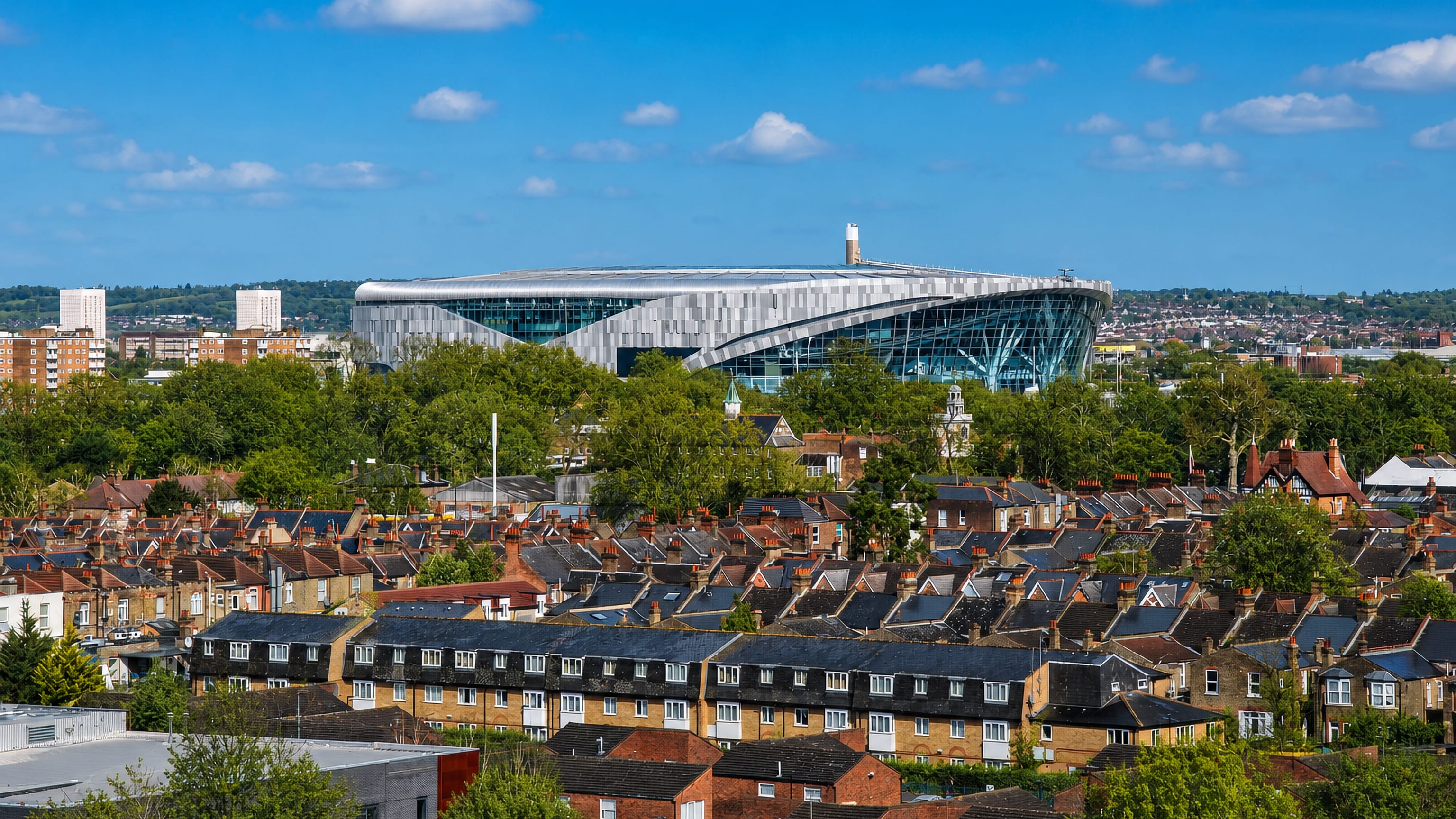 Tottenham Hotspur Stadium rising above rows of Victorian terraced houses in Tottenham, north London.
